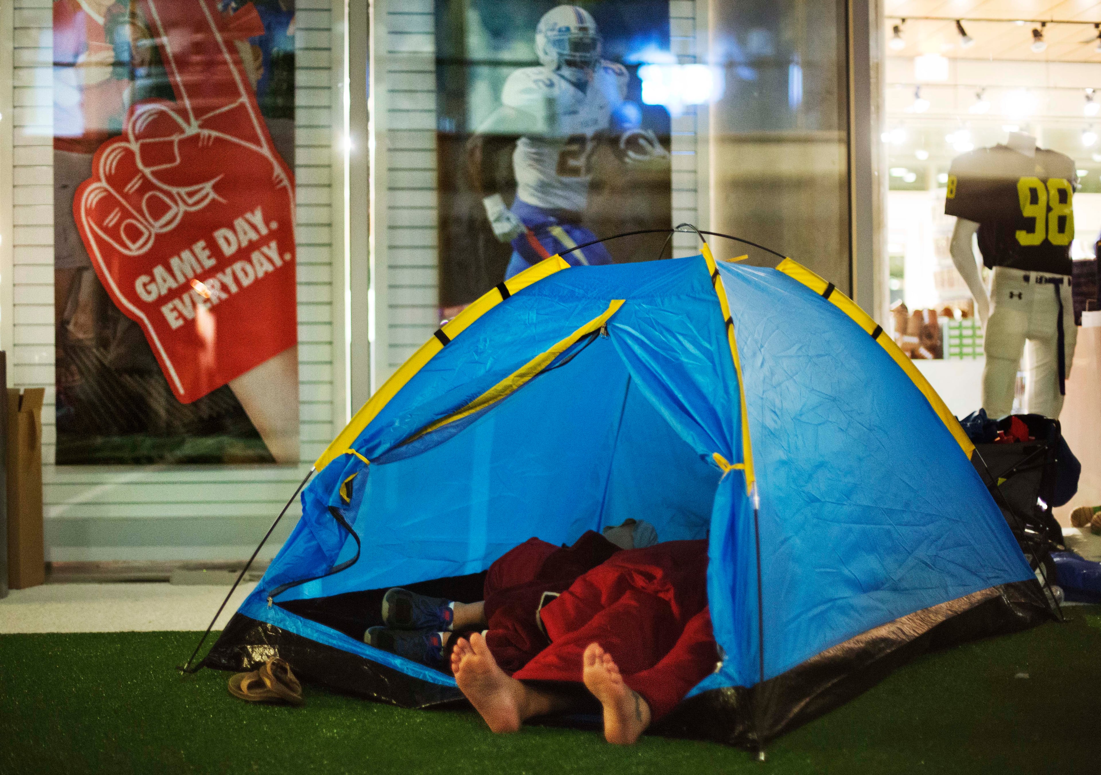 Guests sleep in a tent next to the gift shop during a sleepover in the College Football Hall of Fame, Thursday, Aug. 14, 2014, in Atlanta. After touring the exhibits guest were served dinner on the football field before pitching their tents on the turf and settling in for the night as college football themed movies such as �Rudy� were played. (AP Photo/David Goldman)
