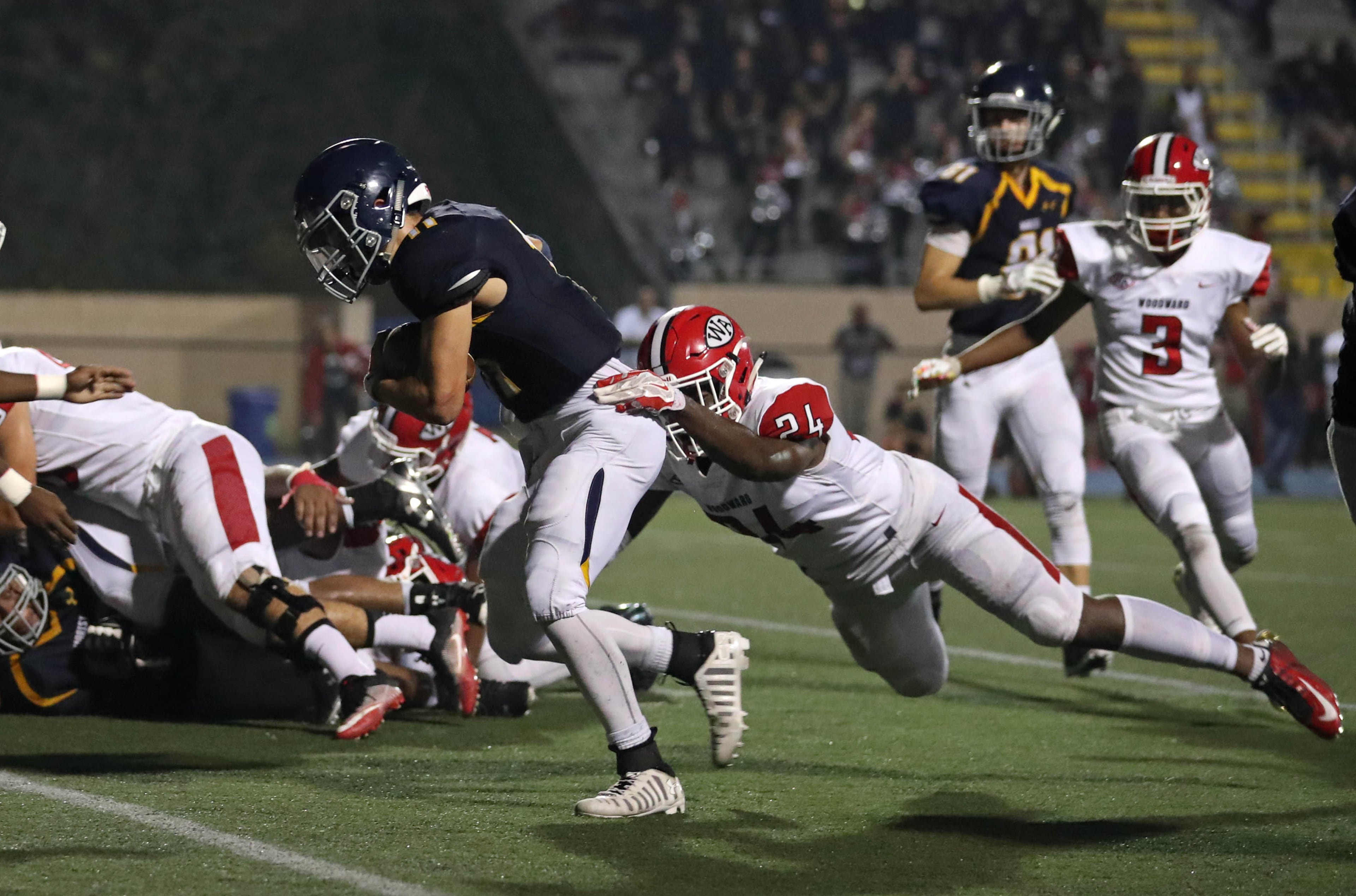 Marist quarterback Chase Abshier (11) scores a rushing touchdown against Woodward Academy linebacker Aaron Washington (24) in the second half at Marist Friday, September 15, 2017, in Atlanta. Marist won 34-17. PHOTO / JASON GETZ