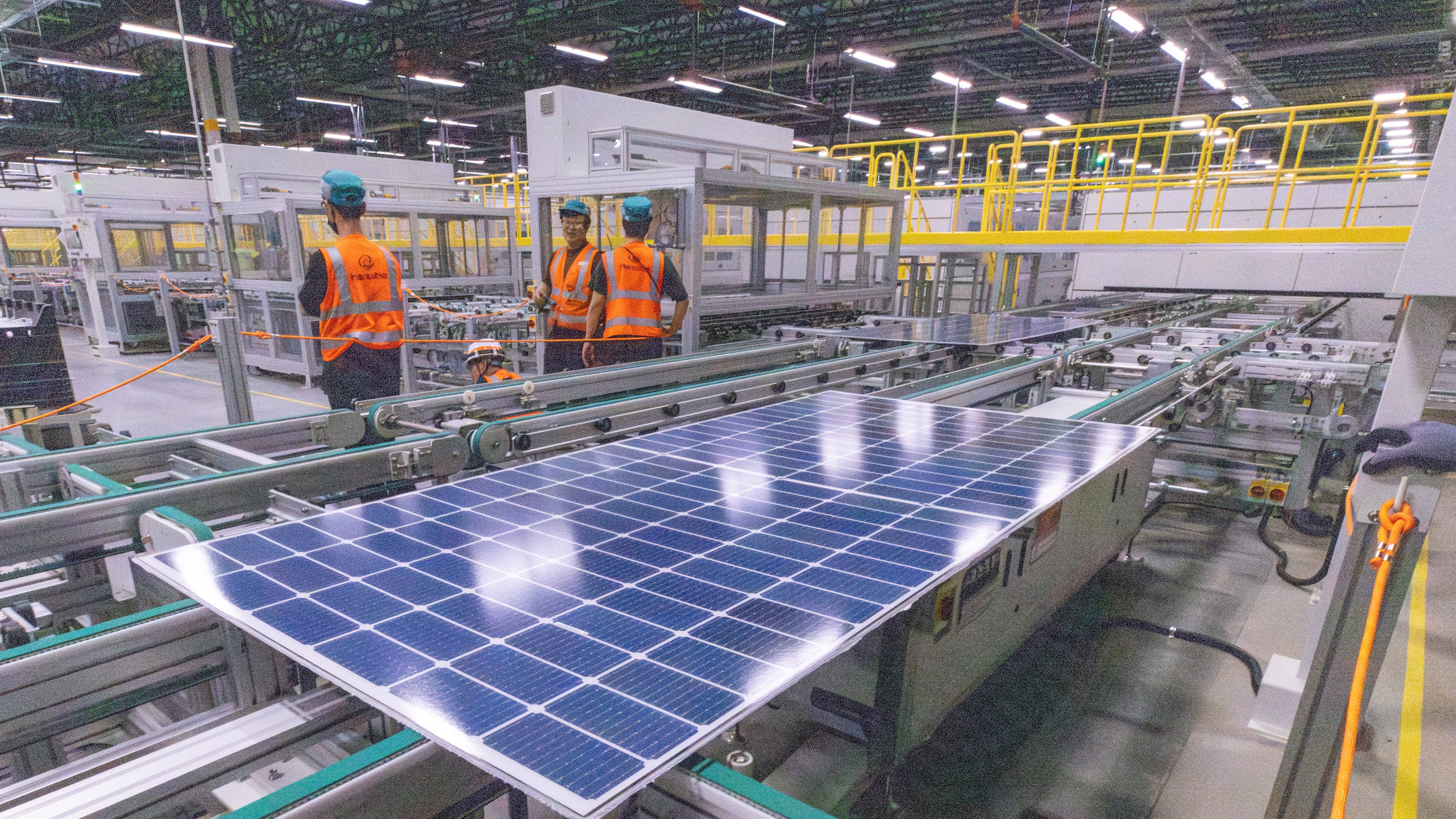 Workers keep an eye on the solar panels as they move through the automated assembly line at the Qcells module production facility in Cartersville on Tuesday, April 2, 2024. (Steve Schaefer/steve.schaefer@ajc.com)