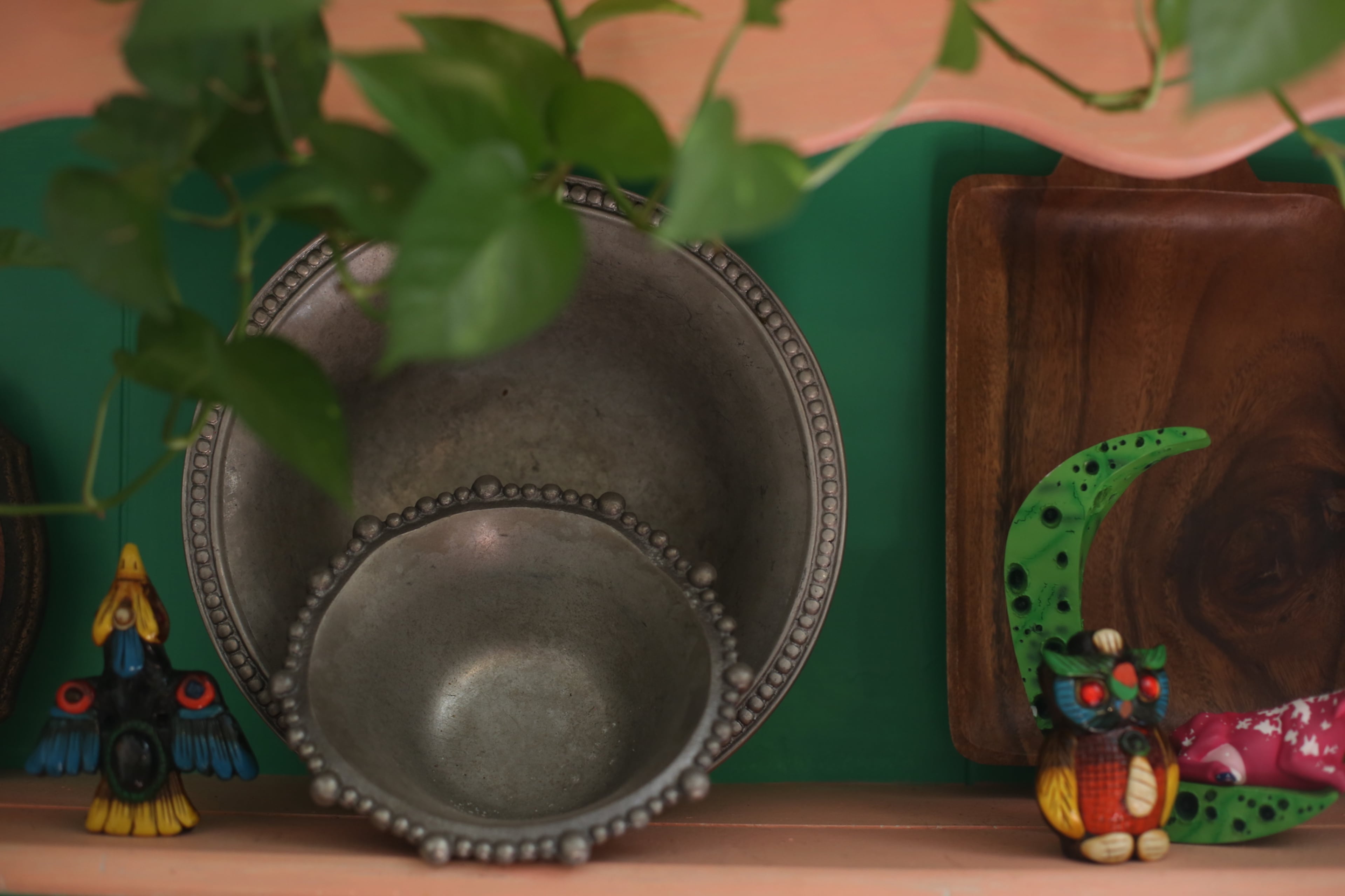 Beaded pewter plates, another thrift store find, are layered on the hutch with wooden items and small sculptures. Even if you have an assortment of knickknacks, if they are arranged on a shelf in an orderly way, it can be visually pleasing, said homeowner Augusta Wheeler. The hutch is painted Valspar's Baby Blush and Coral Reef.