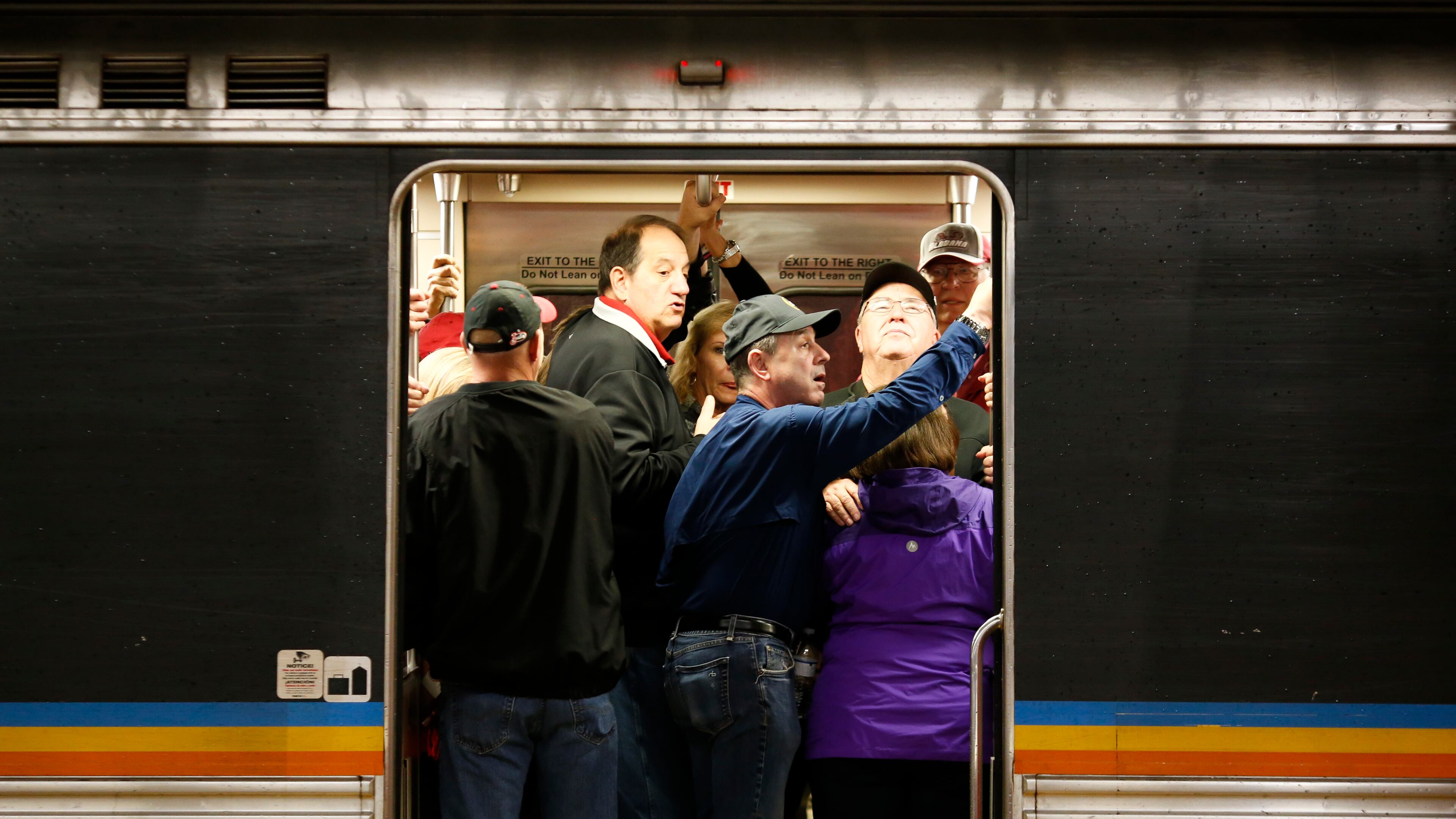 Football fans and other MARTA commuters pack into a train at the Five Points Station shortly before the start of the SEC Championship between Georgia and Alabama in Atlanta on Saturday. The agency put its best foot forward as it seeks to improve its performance during major events. (Casey Sykes for The Atlanta Journal-Constitution)