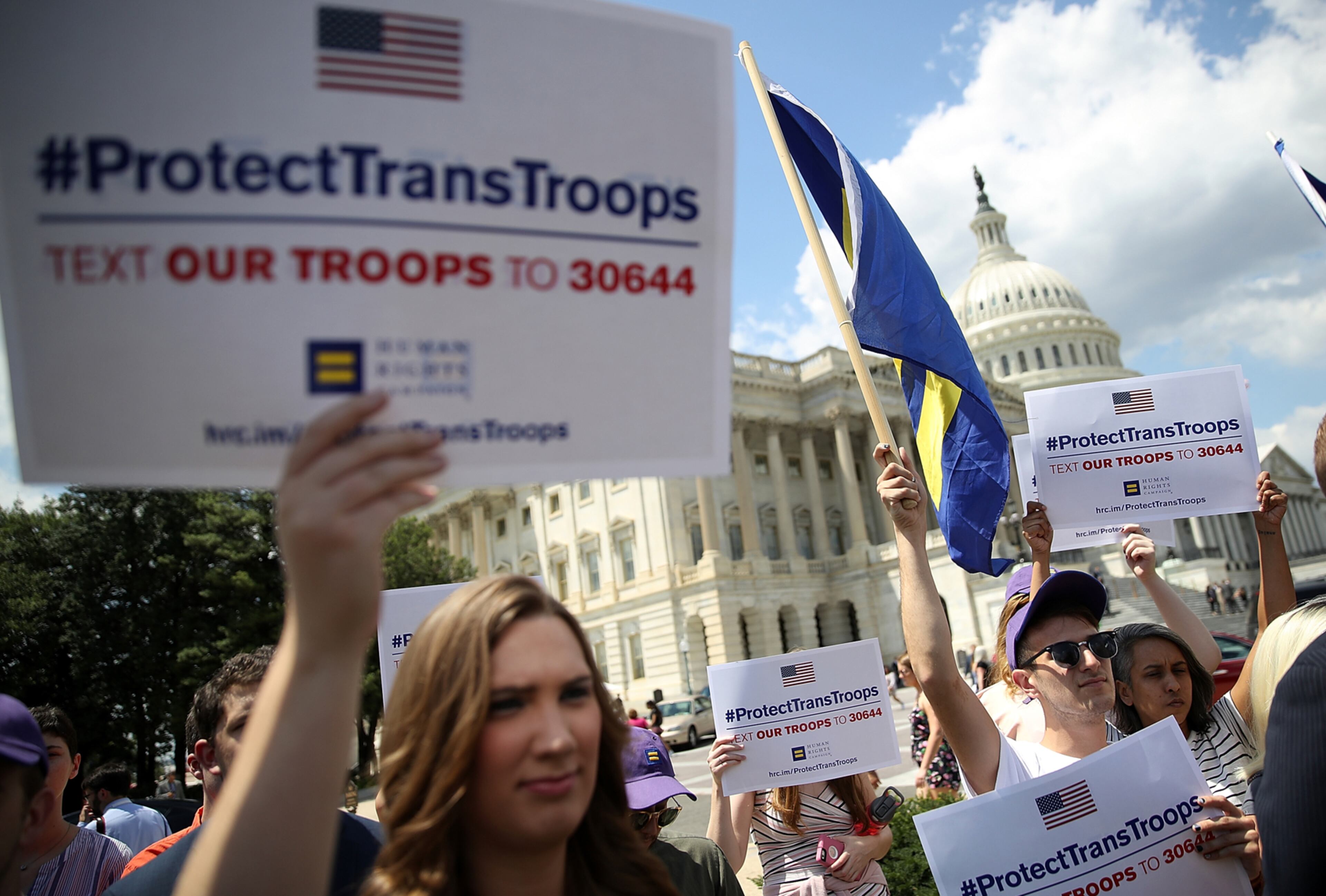 WASHINGTON, DC - JULY 26: Gay rights supporters hold signs during a press conference at the U.S. Capitol condemning the new ban on transgendered servicemembers on July 26, 2017 in Washington, DC. U.S. Rep. Joe Kennedy held a news conference with members of the House leadership and the LGBT Equality Caucus to denounce the decision by U.S. President Donald Trump to ban transgendered servicemembers. (Photo by Justin Sullivan/Getty Images)