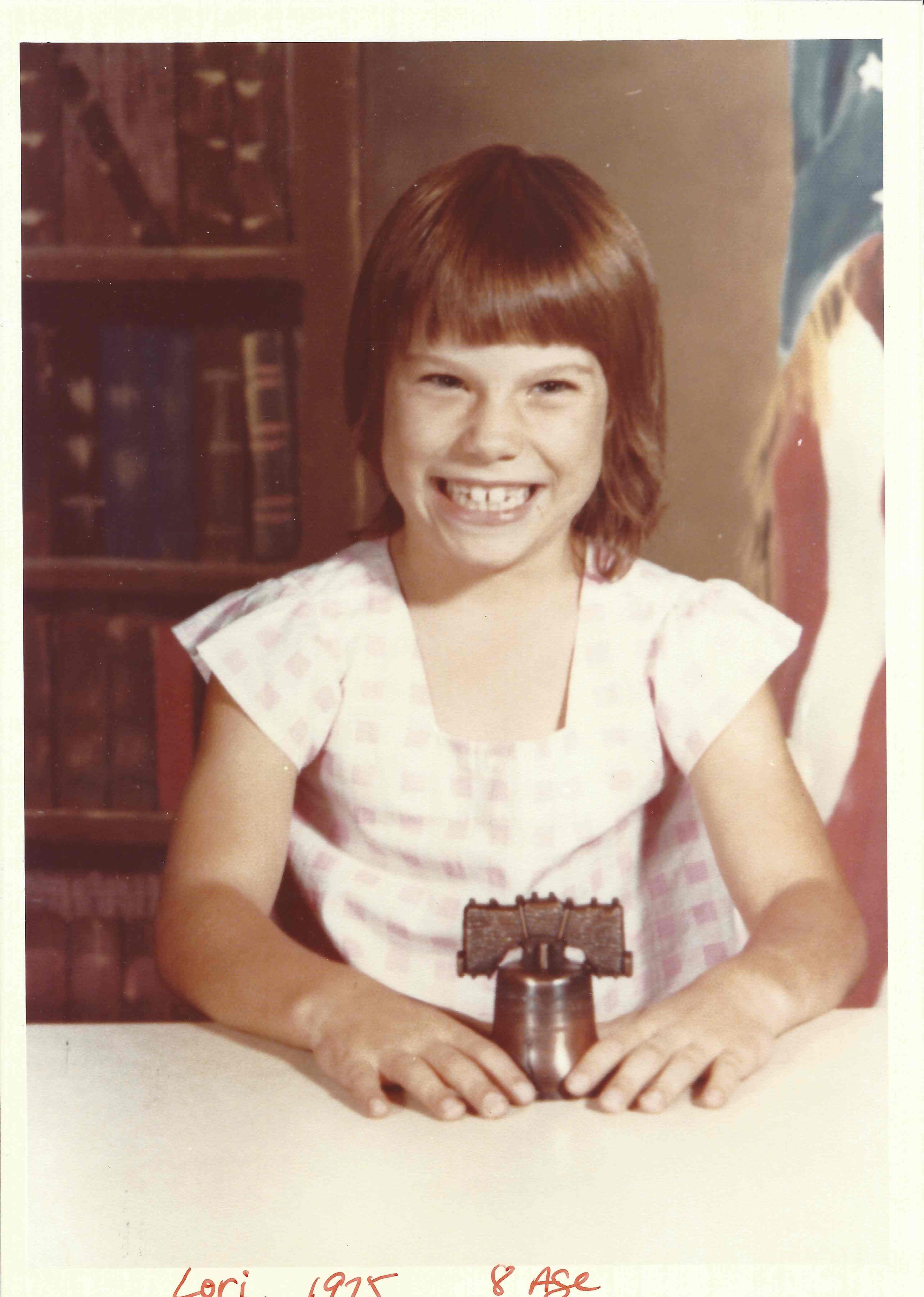 Lori Ann Smith poses with a miniature replica of the Liberty Bell in 1976. With her grandparents in Kentucky, she liked milking cows, riding horses, and searching for kittens in the barn. (Courtesy of the Smith family)
