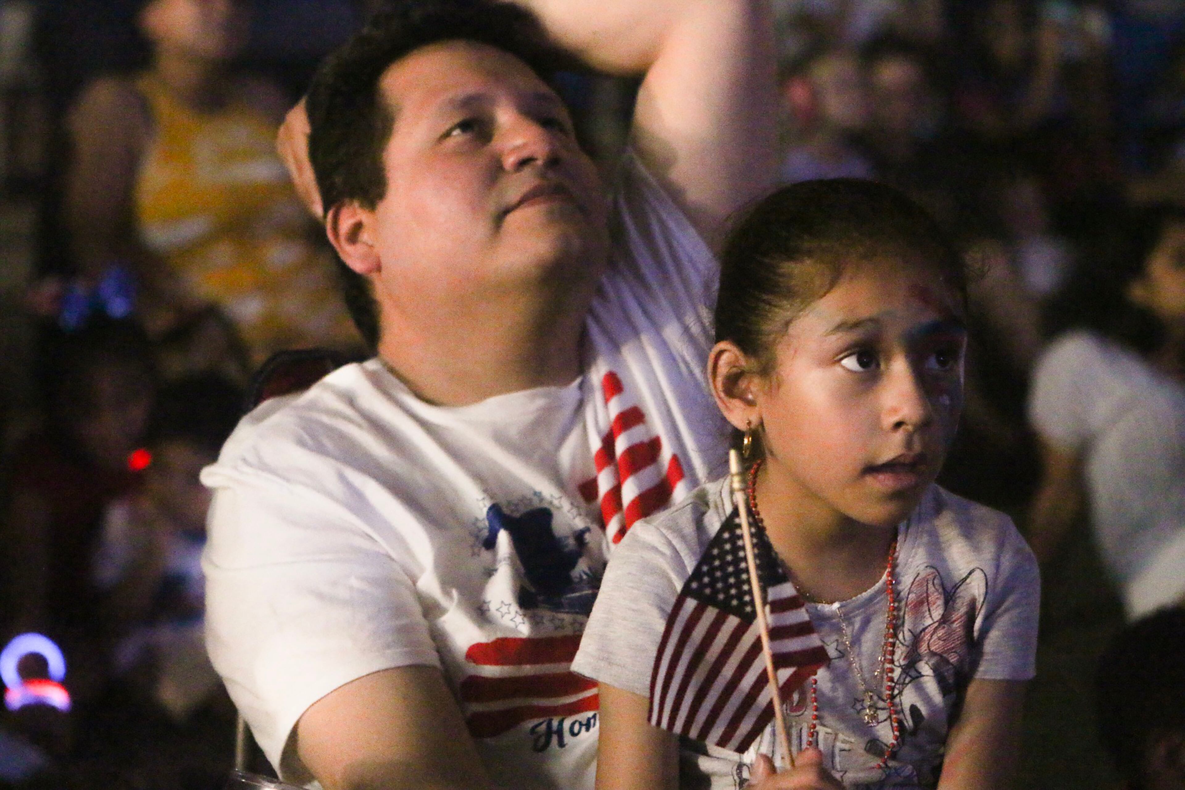A girl sits on her fathers's lap while they watch fireworks at Centennial Olympic Park. Christina Matacotta/Christina.Matacotta@ajc.com