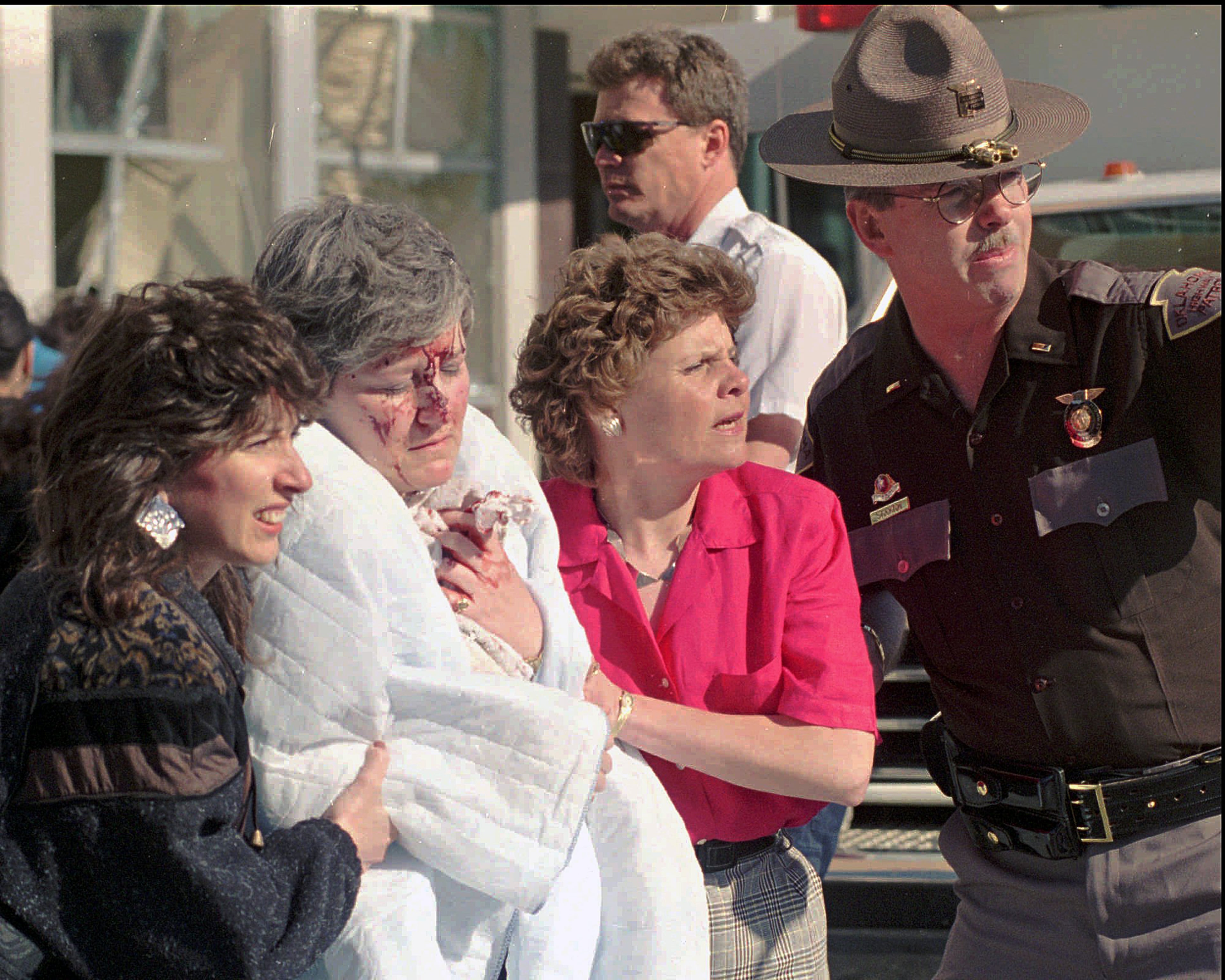 In this April 19, 1995 file photo, a victim of the explosion that ripped a nine-story hole in the the Alfred Murrah Federal Building Wednesday, April 19, 1995, in downtown Oklahoma City, is helped from the scene. The blast killed 168 people _ including 19 children _ injured hundreds more and caused hundreds of millions of dollars in damage to structures and vehicles in the downtown area. (AP Photo/J. Pat Carter)