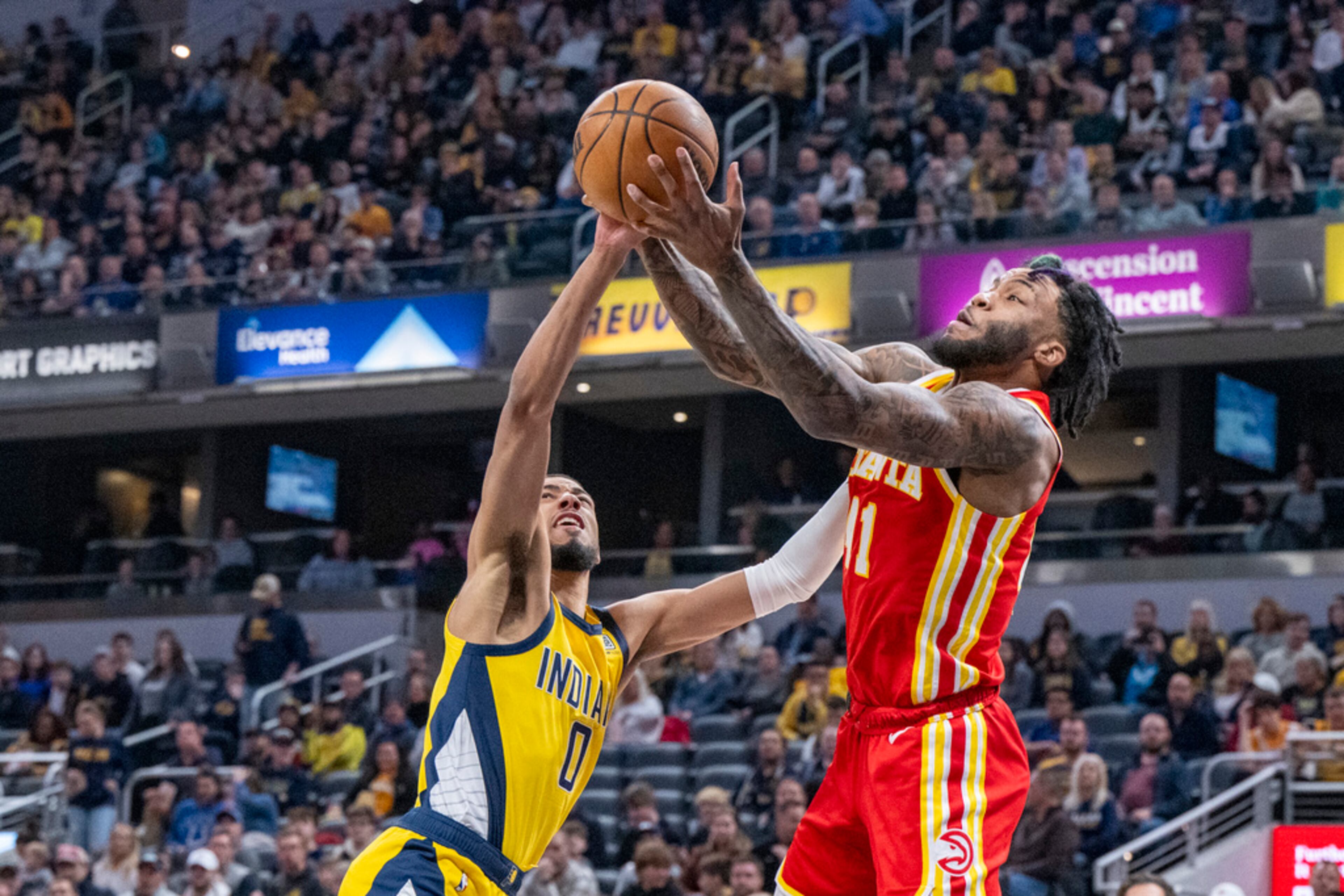 Atlanta Hawks forward Saddiq Bey (41) and Indiana Pacers guard Tyrese Haliburton (0) vie for a rebound during the first half of an NBA basketball game in Indianapolis, Friday, Jan. 5, 2024. (AP Photo/Doug McSchooler)