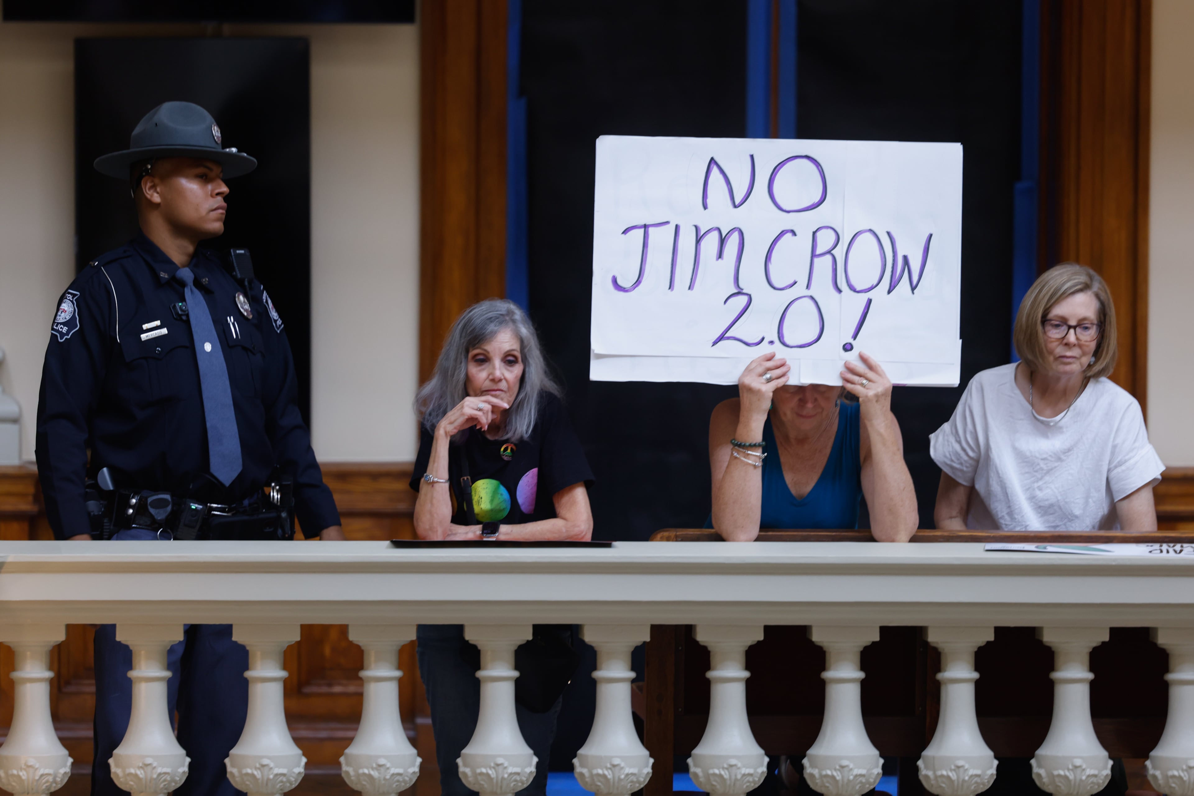 An activist holds a “No Jim Crow 2.0” sign at a press conference before the state legislature convenes for a special session in Atlanta on June 17, 2026. (Arvin Temkar/AJC)