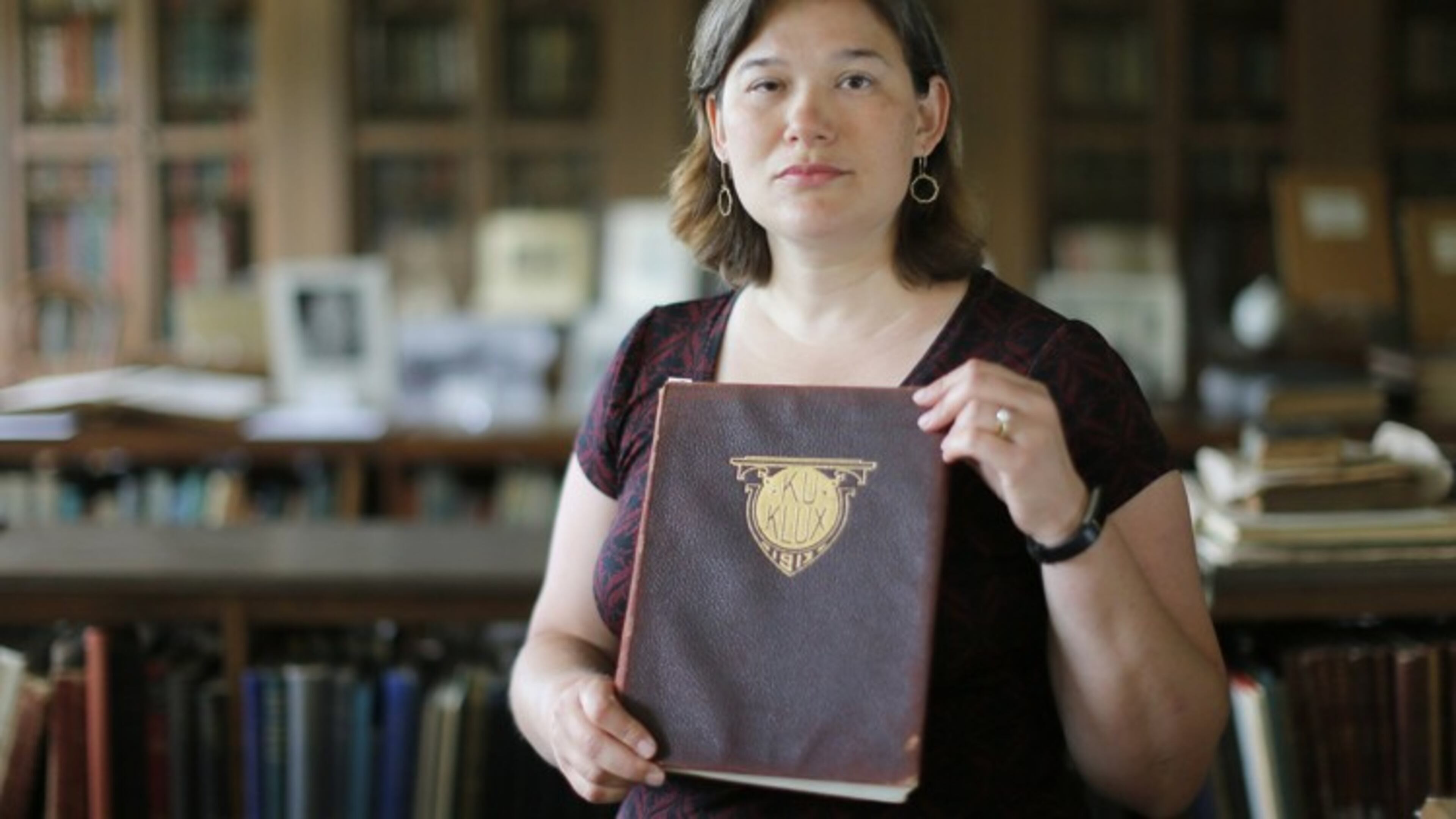 Associate Professor of History at Wesleyan College, Karen Huber, holds a 1913 edition of the college’s yearbook titled “Ku Klux”.