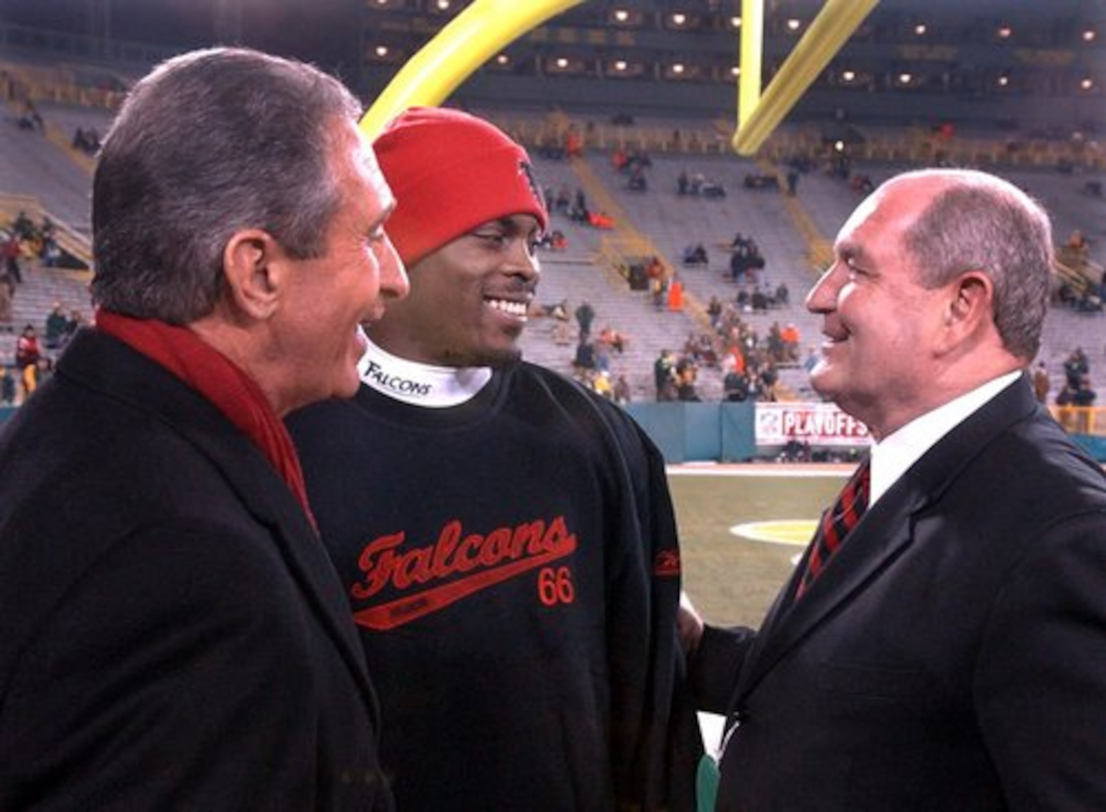 Former Gov. Sonny Perdue, right, tells Atlanta Falcons quarterback Michael Vick, "Michael, you can win against all odds, I've done it," as team owner Arthur Blank, left, looks on before the Falcons upset Green Bay to become the first team to win a playoff game at Lambeau Field.