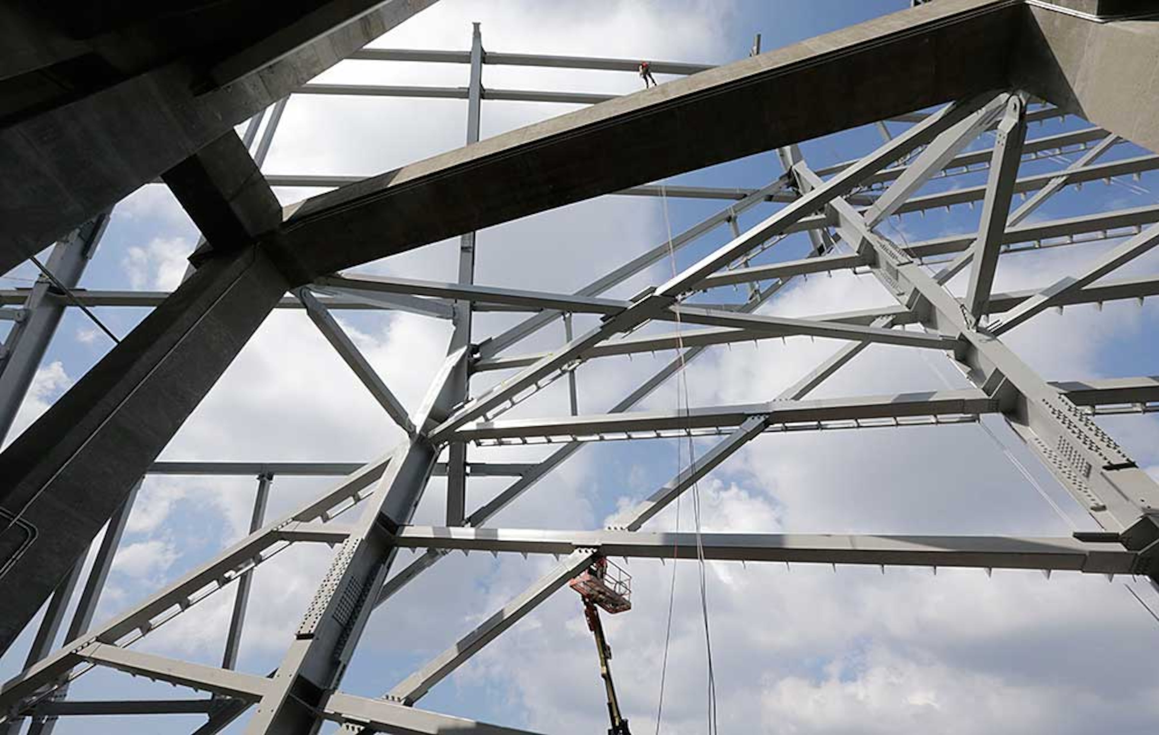 Looking outward from the upper concourse, erection of the facade steel is visible around the exterior of the stadium.