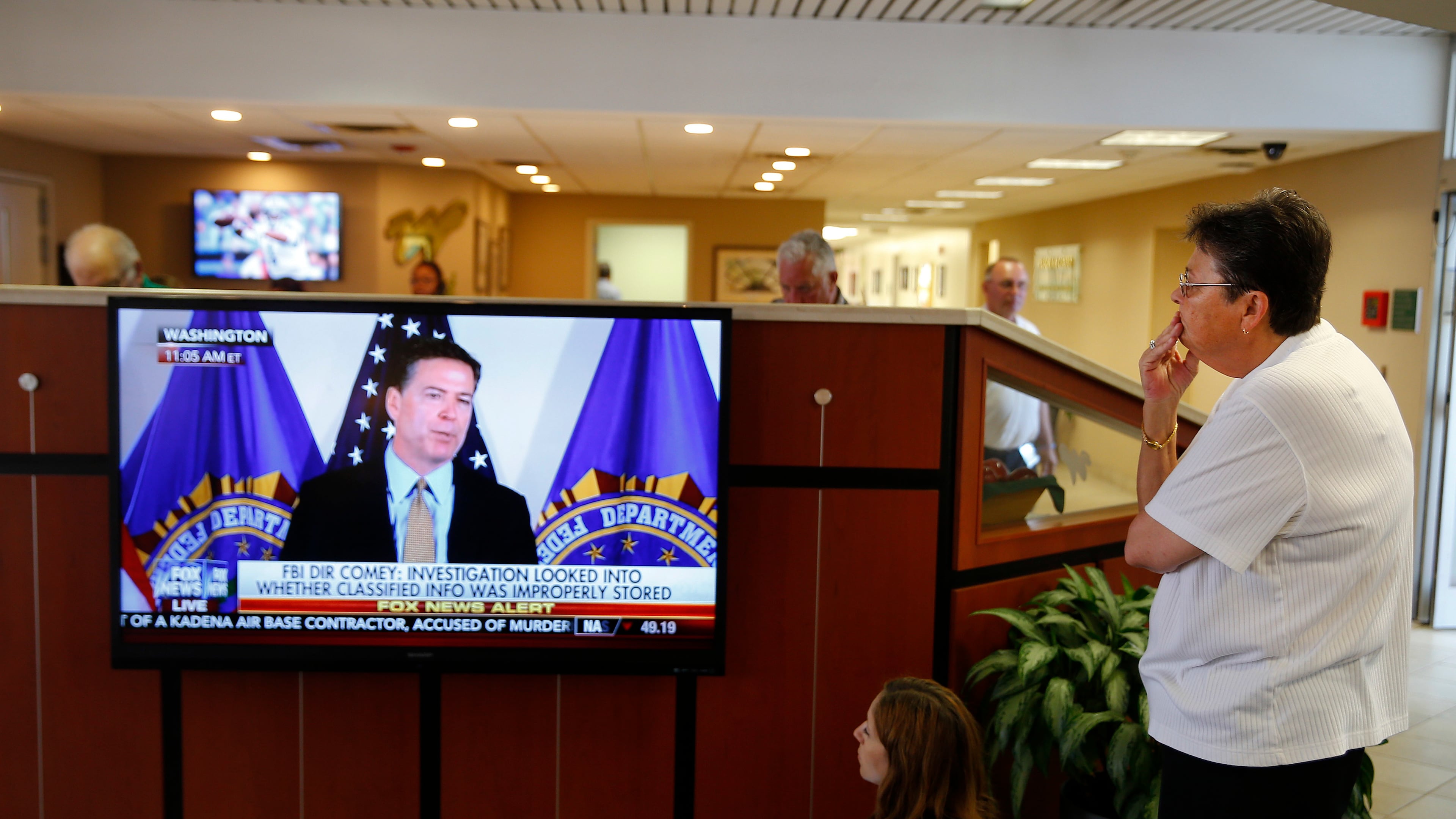A woman watches as FBI Director James Comey announces the results of his department's investigation into former Secretary of State and Democratic presidential candidate Hillary Clinton's handling of classified emails on Tuesday in Charlotte, N.C.. Clinton was expected to appear with at President Barack Obama in Charlotte later in the day. AP/John Bazemore