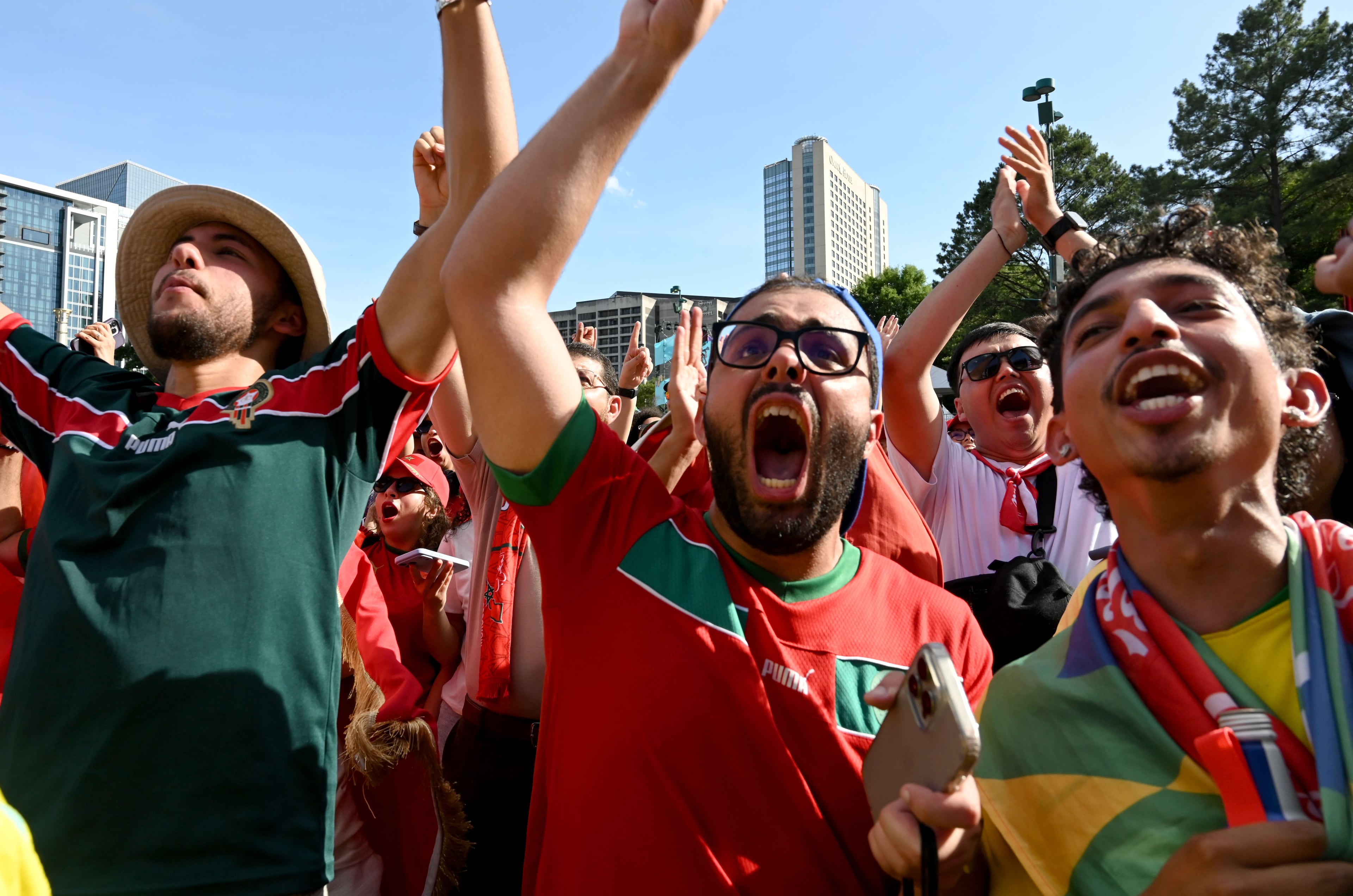 Local Moroccan fans cheer loudly as they watch the match against Brazil on a screen during a watch party at the FIFA Fan Festival. (Hyosub Shin/AJC)
