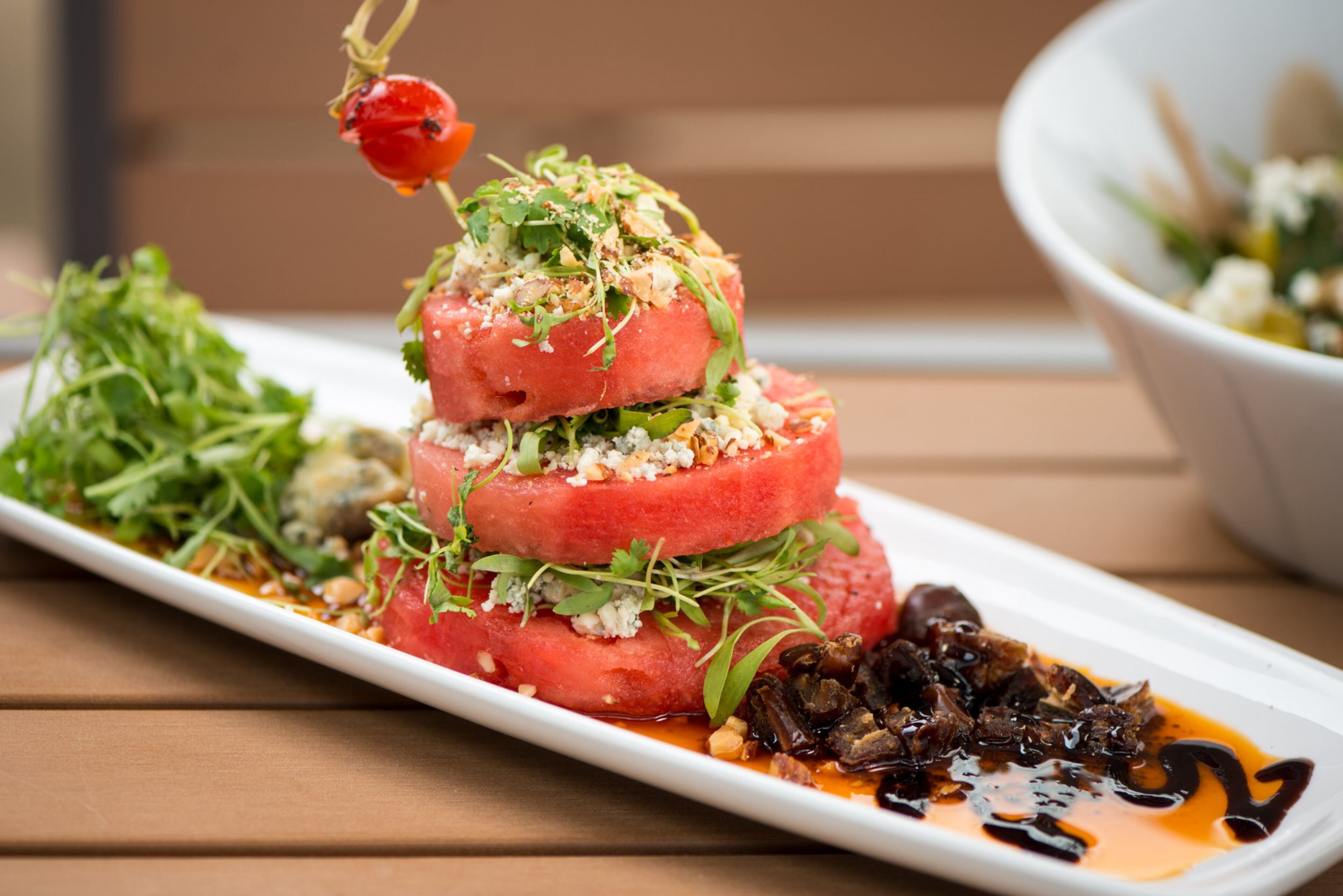 One of the new items at Sage Woodfire Tavern in Buckhead is Roquefort Watermelon Bleu Napoleon with smoked almond, date, baby cilantro, and agave poppyseed vinaigrette. Photo credit- Mia Yakel.