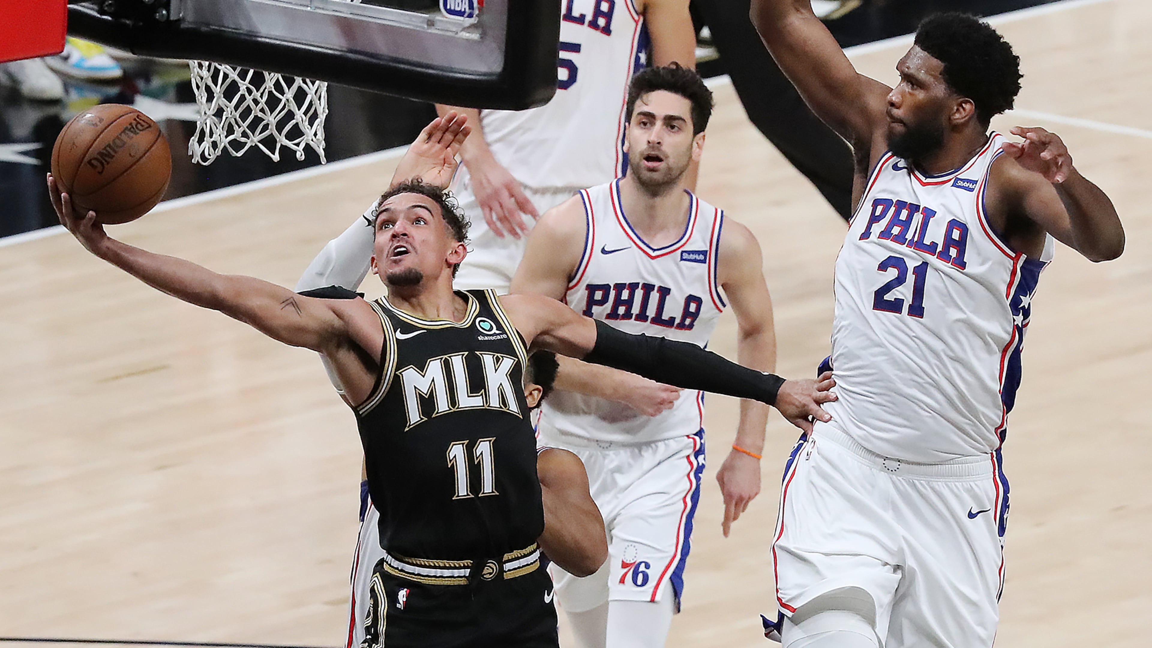 Trae leads Hawks to Game 4 victory: Trae Young draws a foul from 76ers center Joel Embiid in the final minute of Monday's 103-100 victory at State Farm Arena. Young had 25 points and 18 assists in the win. (Curtis Compton/Curtis.Compton@ajc.com)