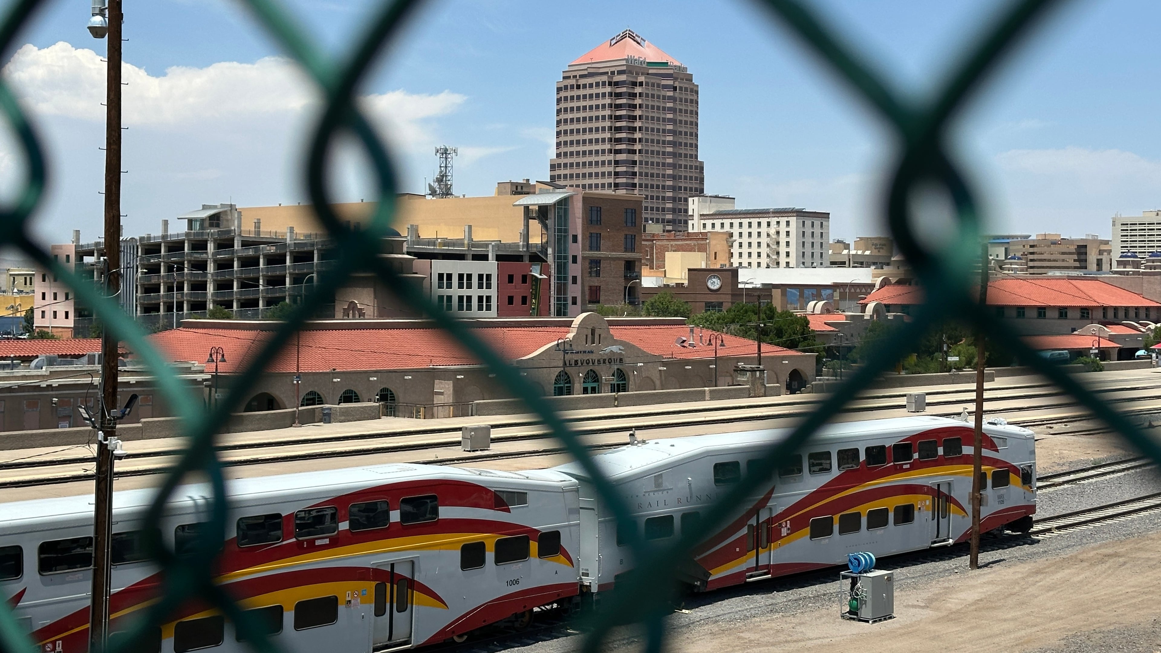 The tallest building in downtown Albuquerque, N.M., which houses the U.S. attorney's office, is seen beyond a chain link fence on Friday, June 12, 2026. (AP Photo/Susan Montoya Bryan)