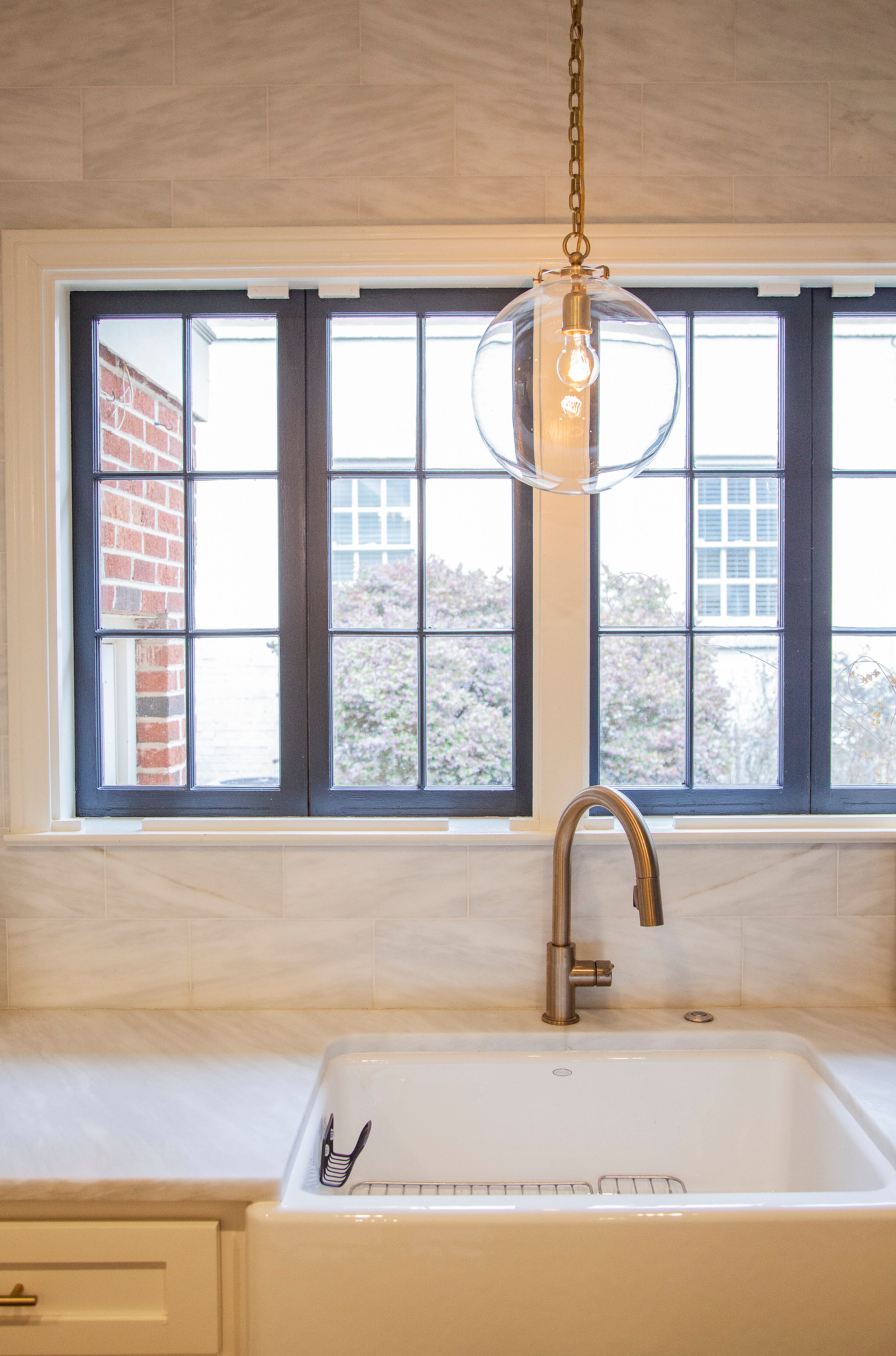 In the kitchen, the Wickings chose Nova Blanca marble for the countertop and backsplash because it's known for being a high-traffic marble that doesn't stain easily, Nicole Wicking said. The glass pendant is from Circa Lighting.