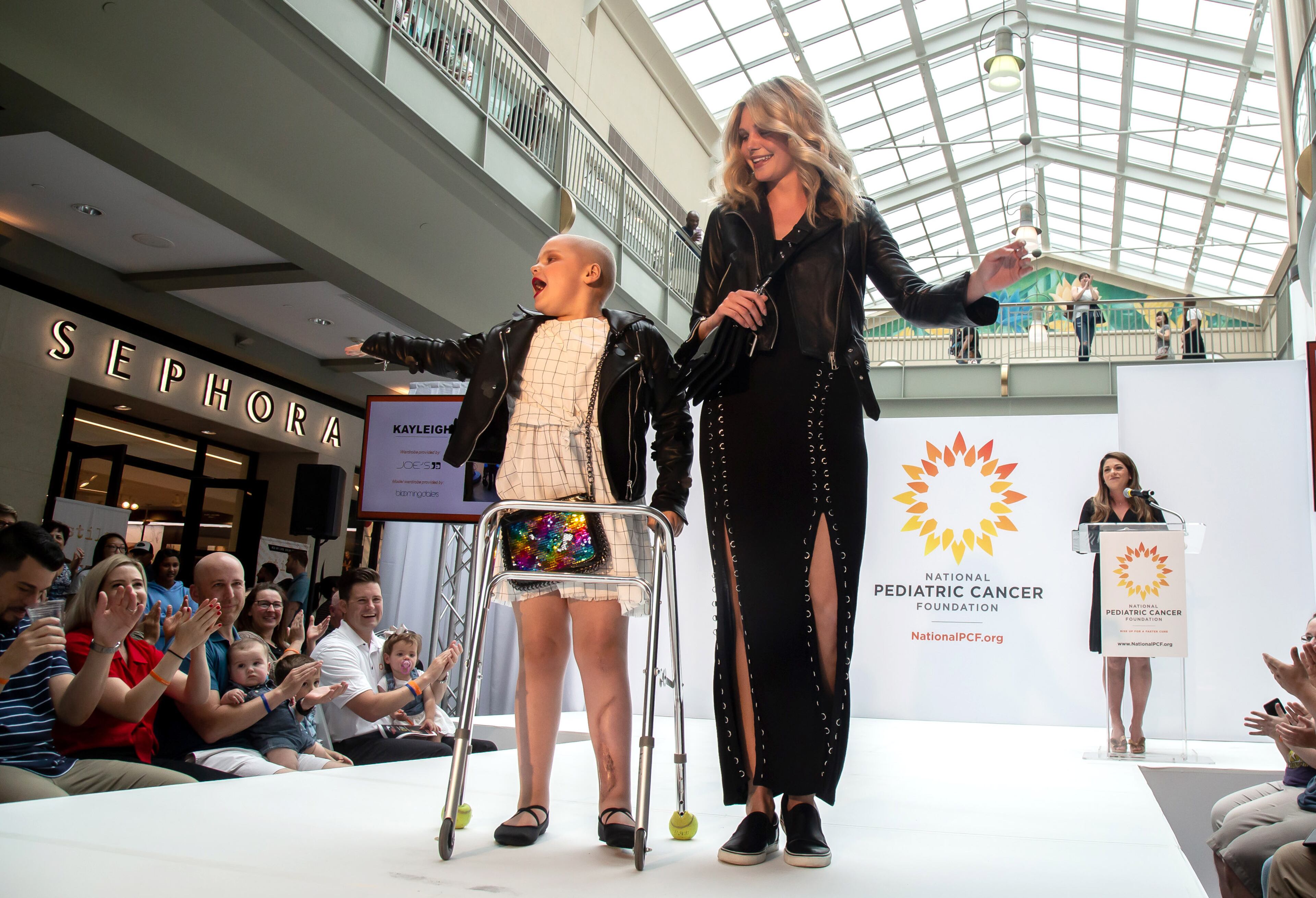 Kayleigh Waldrop,7, along with a professional model pause at the end of the runway during Fashion Funds the Cure, a fashion show benefiting The National Pediatric Cancer Foundation at Lenox Square in Atlanta on Saturday, May 4, 2019. STEVE SCHAEFER / SPECIAL TO THE AJC