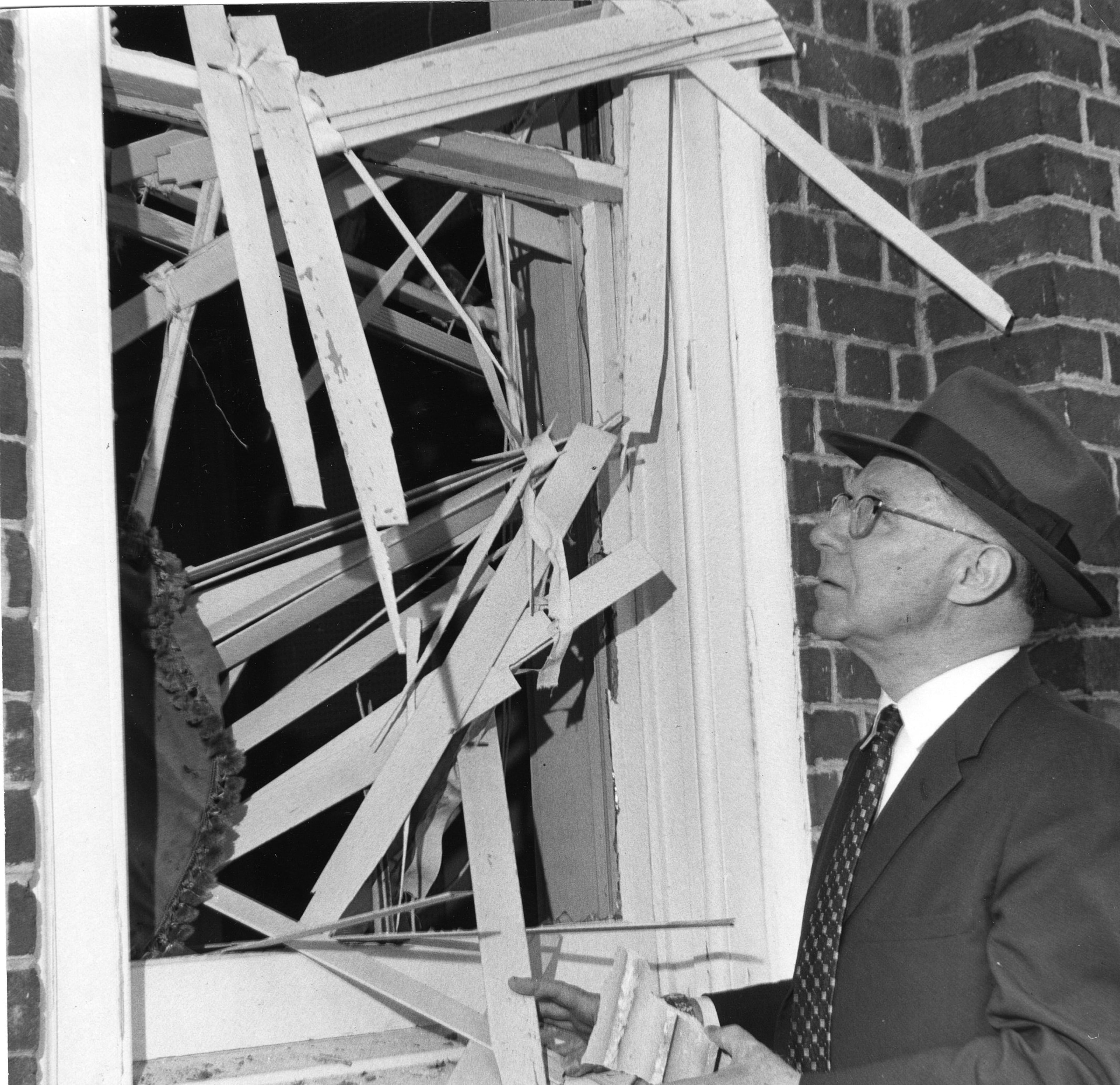 Mayor Hartsfield examines the damage done to a window as a result of the Hebrew Benevolent Congregation bombing in Atlanta, October 1958. What came to be known as the "Temple bombing" was an attack by white supremacists on the Temple, which had been a center for civil rights advocacy during the '50s. Nobody was injured in the blast.