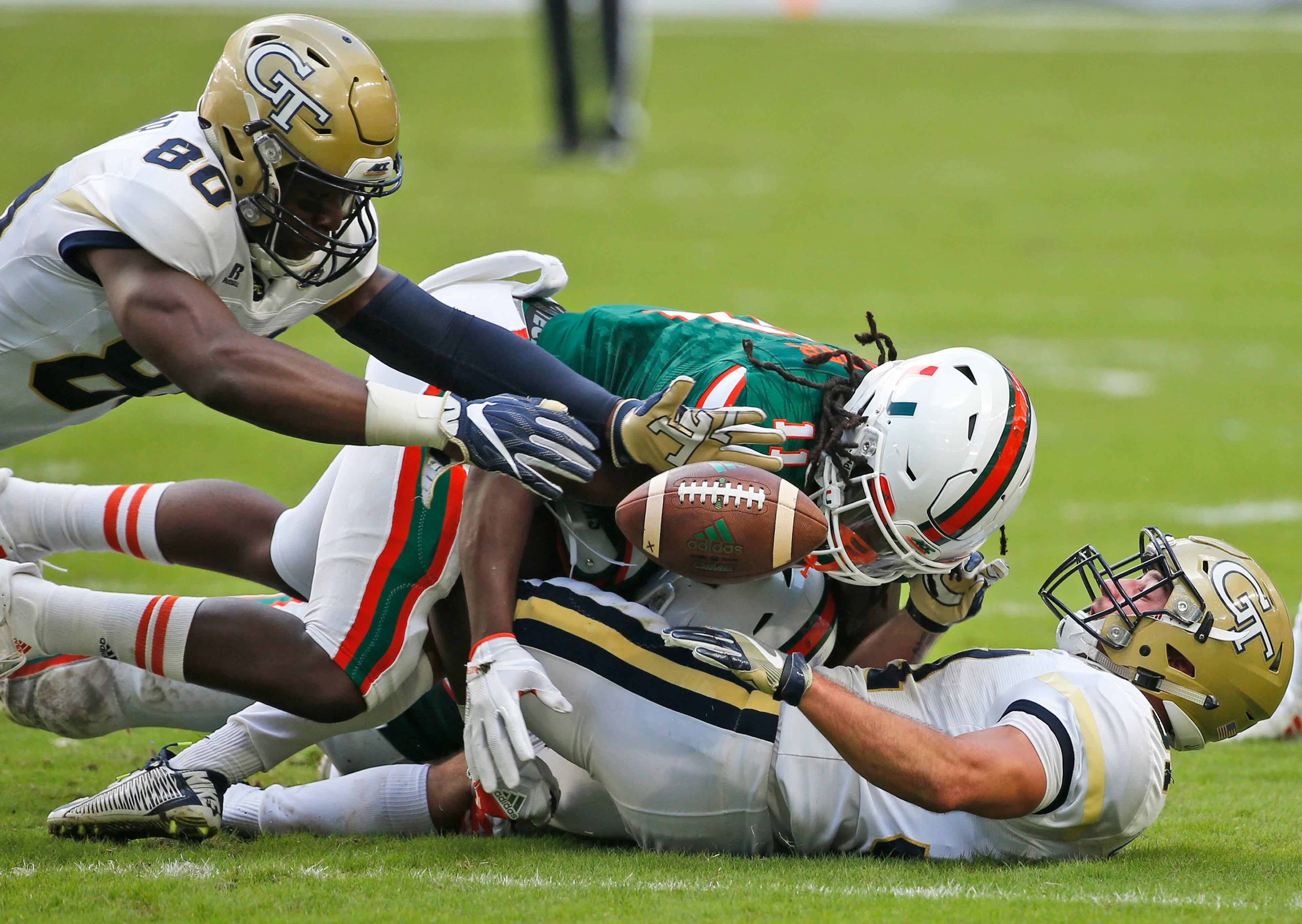 Georgia Tech wide receiver Jalen Camp (80) recovers a fumble by running back Nathan Cottrell, right, as he is tackled by Miami linebacker De'Andre Wilder during the first half of an NCAA College football game, Saturday, Oct. 14, 2017 in Miami Gardens, Fla. (AP Photo/Wilfredo Lee)