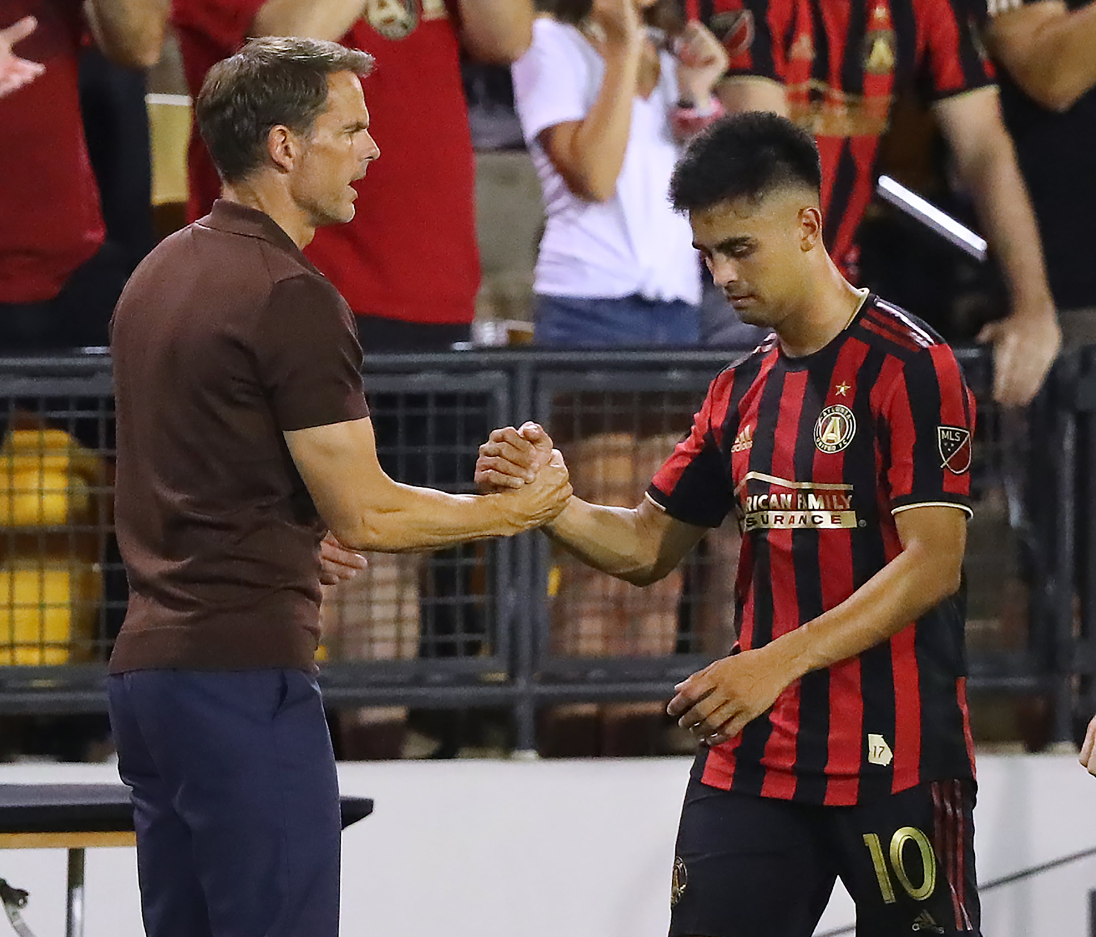 Atlanta United midfielder Pity Martinez gets five from head coach Frank de Boer. Curtis Compton/ccompton@ajc.com