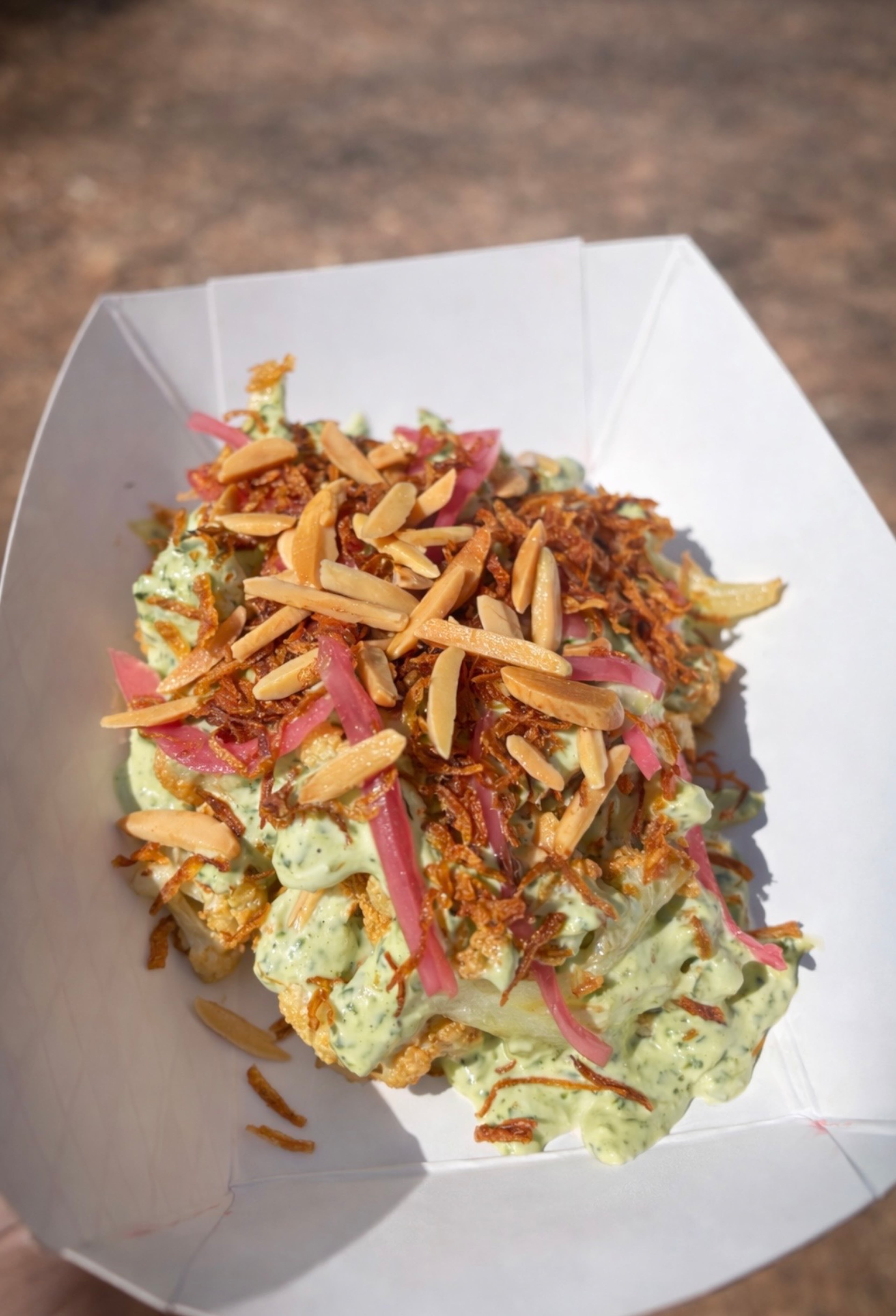 Charred cauliflower with herb yogurt, slivered almonds, fried onions and pickled onions from Habibi's. (Courtesy of Habibi's)