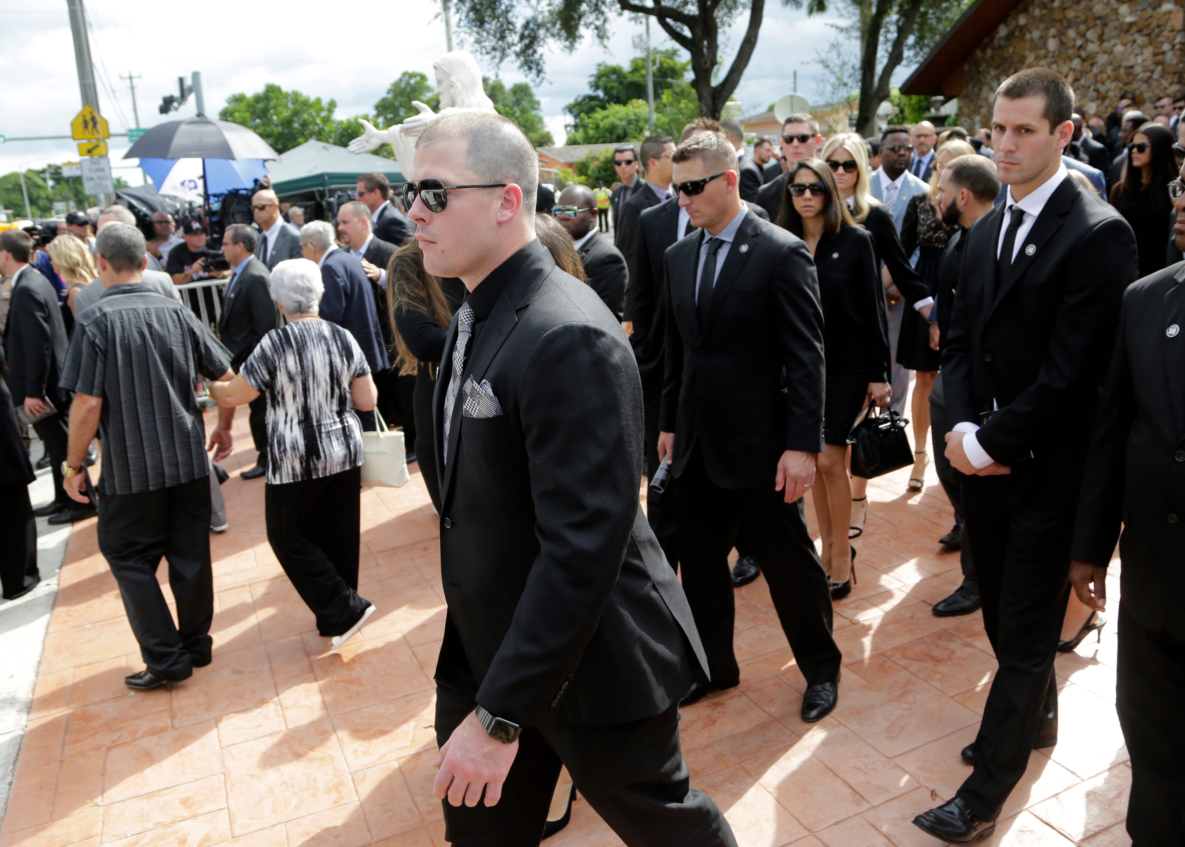 Miami Marlins first baseman Justin Bour, left, leaves a memorial service for Miami Marlins pitcher Jose Fernandez, at St. Brendan's Catholic Church, Thursday, Sept. 29, 2016, in Miami. Fernandez was killed in a boating accident Sunday along with two friends. (AP Photo/Lynne Sladky)