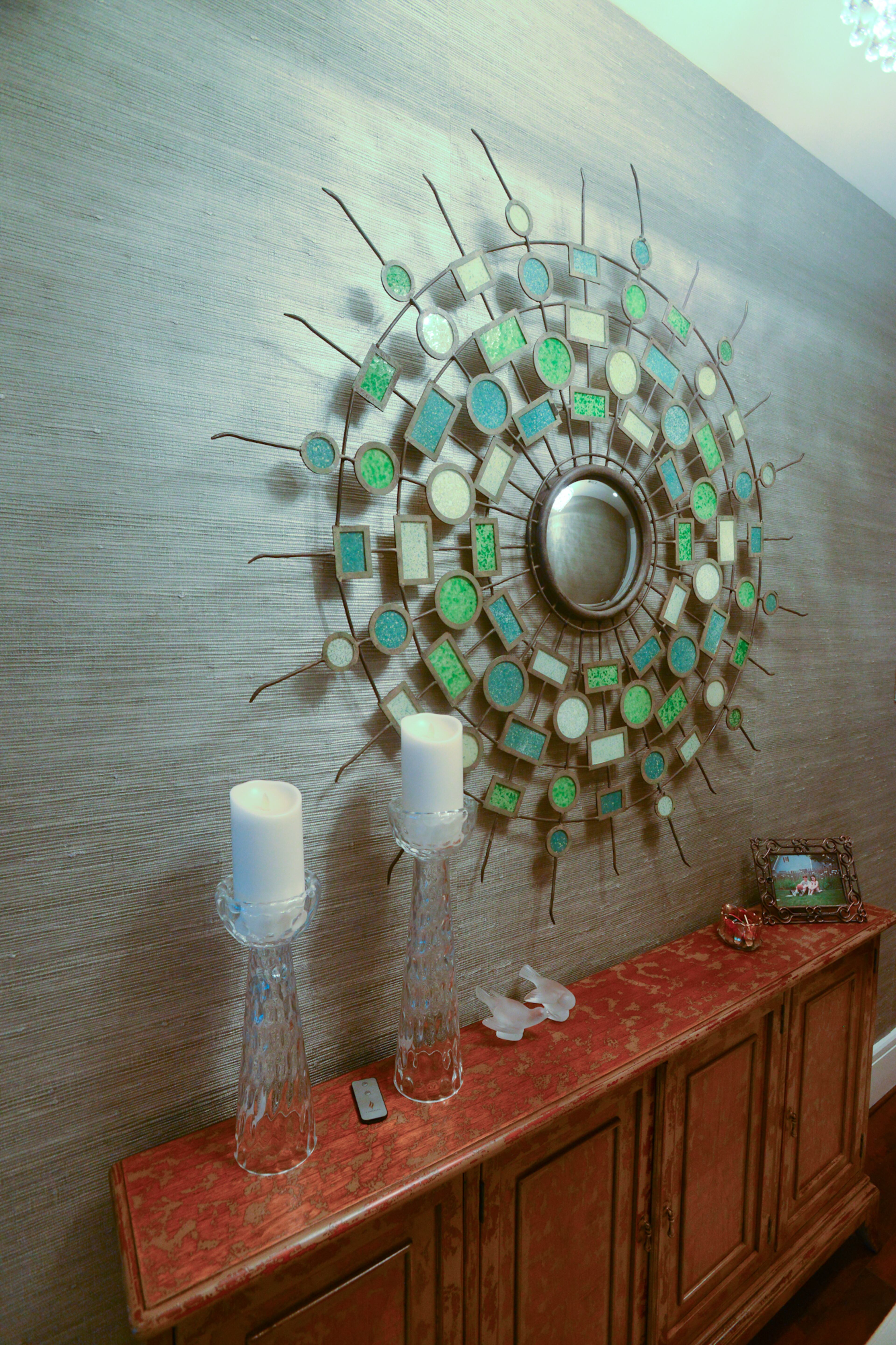 Bringing wallpaper into his modern condo was a stretch for homeowner Jim Wilson, who hadn't used it before. Wilson looked to Wallpaper & Stuff to find something that would dress up the walls and add texture in the hallway, where Wilson makes a statement with silver metallic grasscloth, a colorful sunburst mirror and the Maguire four-door cabinet.