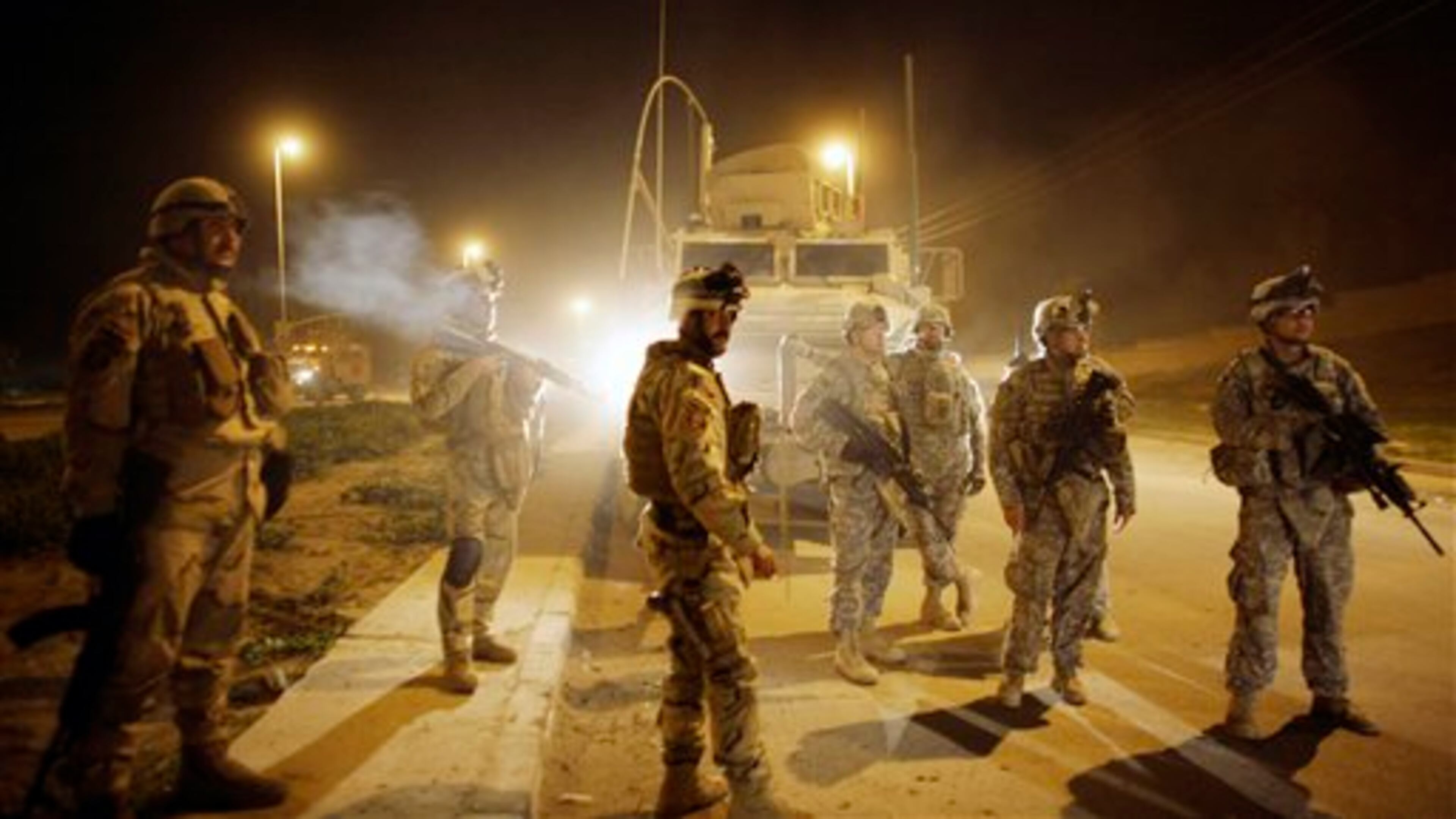 FILE - In this March 7, 2010 file photo, U.S. Army soldiers from B Troop, 3rd Squadron, 7th Cavalry Regiment and Iraqi Army soldiers watch comrades detain men suspected of planting a roadside bomb after polls closed for the national election in Mosul, north of Baghdad, Iraq. TThe former top U.S. commander in northern Iraq defended the multibillion dollar American effort to train Iraqi security forces despite this week's Sunni insurgent offensive that has seen key cities occupied as soldiers and police abandoned their posts. Mark Hertling, a retired general who led American forces in the volatile region in 2007-2008 as they fought to end sectarian warfare that pushed the country to the brink of civil war, said Thursday, June 12, 2014 that neglect by the Shiite-led government left Iraq in a precarious position and "squandered" the opportunity for real progress. (AP Photo/Maya Alleruzzo, File)