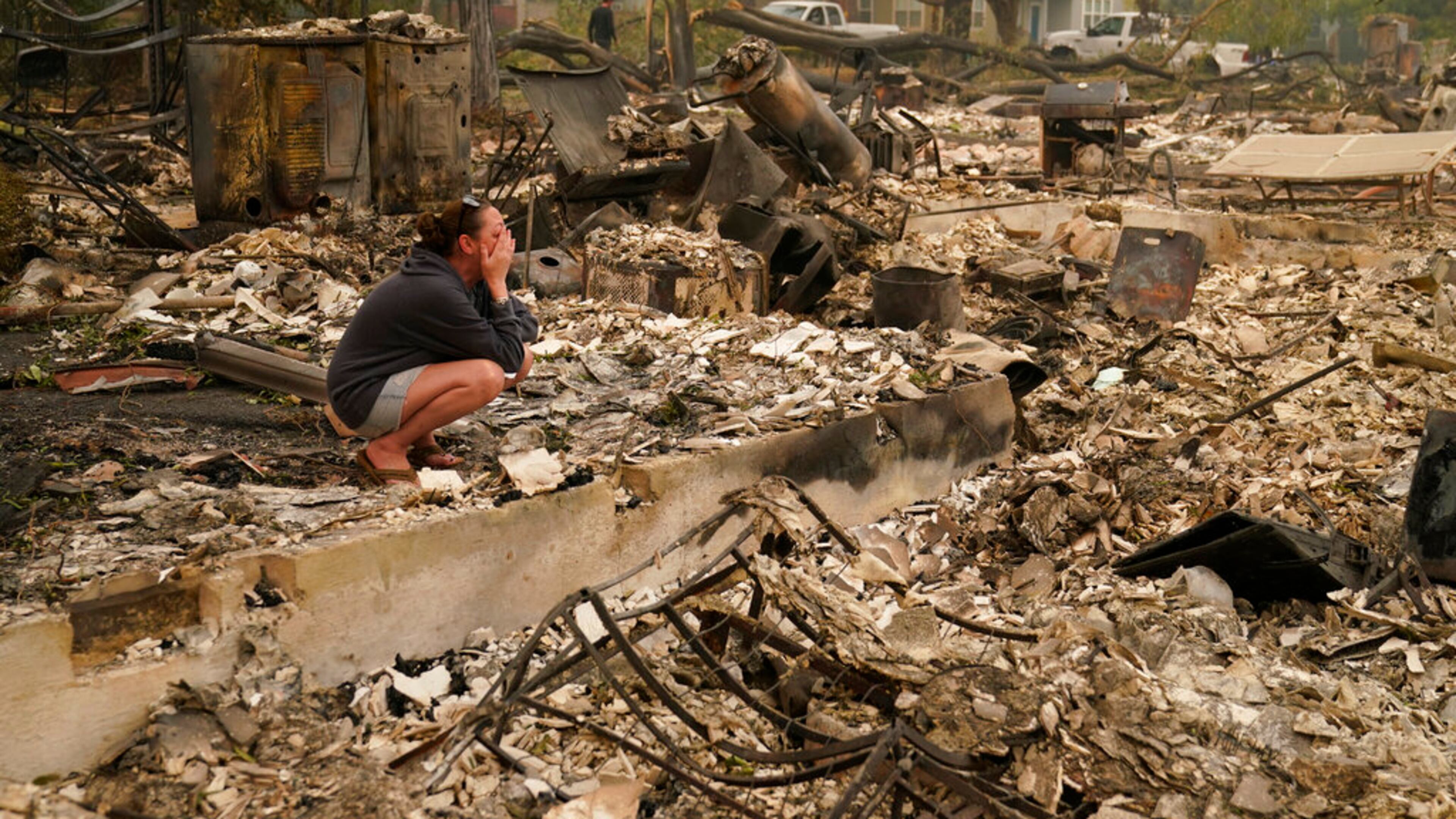 Desiree Pierce cries as she visits her home destroyed by the Almeda Fire, Friday, Sept. 11, 2020, in Talent, Ore. "I just needed to see it, to get some closure," said Pierce. (AP Photo/John Locher)