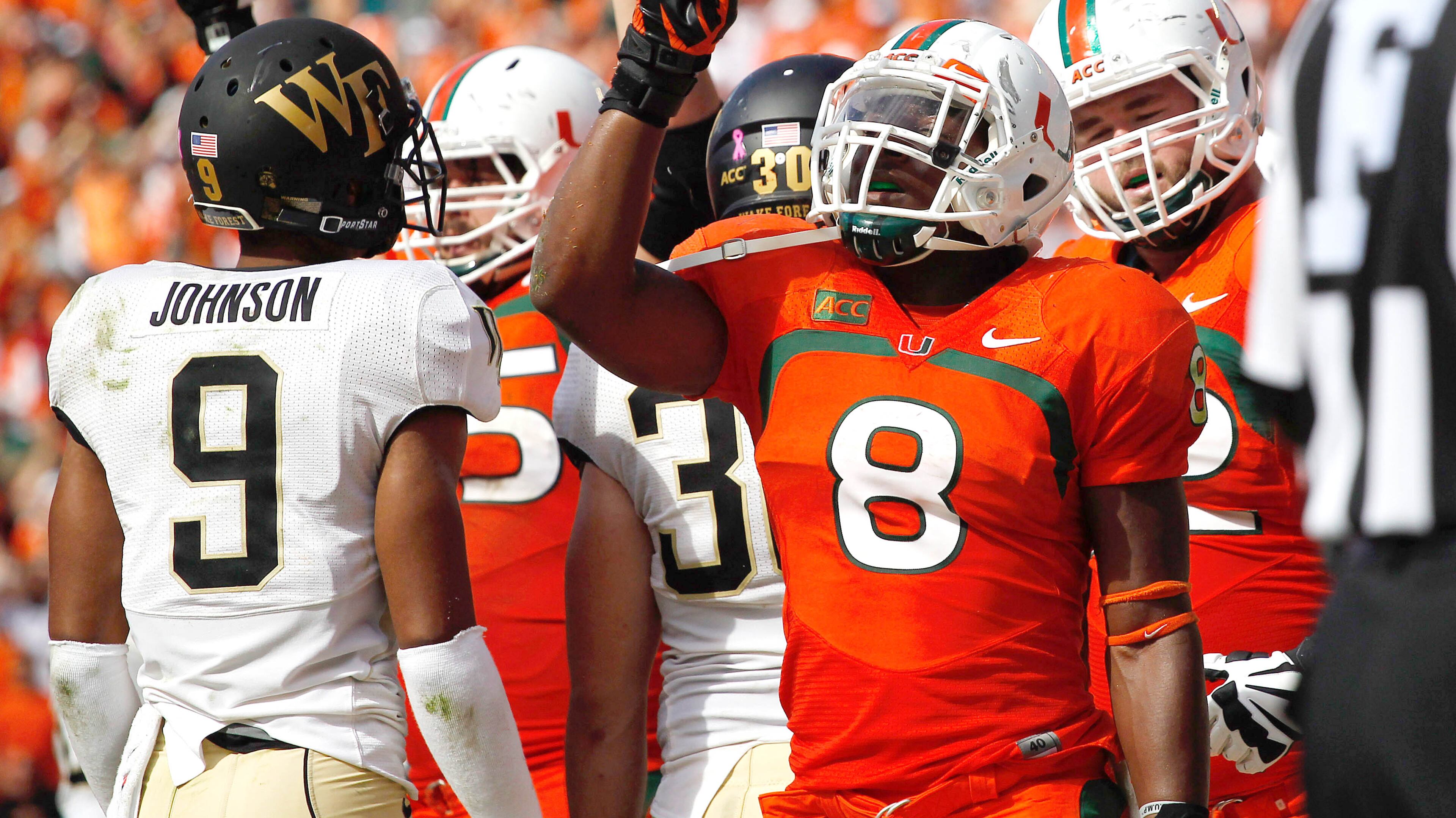 Oct 26, 2013; Miami Gardens, FL, USA; Miami Hurricanes running back Duke Johnson (8) reacts after scoring the game winning touchdown in the fourth quarter as Wake Forest Demon Deacons cornerback Kevin Johnson (9) looks on at Sun Life Stadium. Miami won 24-21. Mandatory Credit: Robert Mayer-USA TODAY Sports