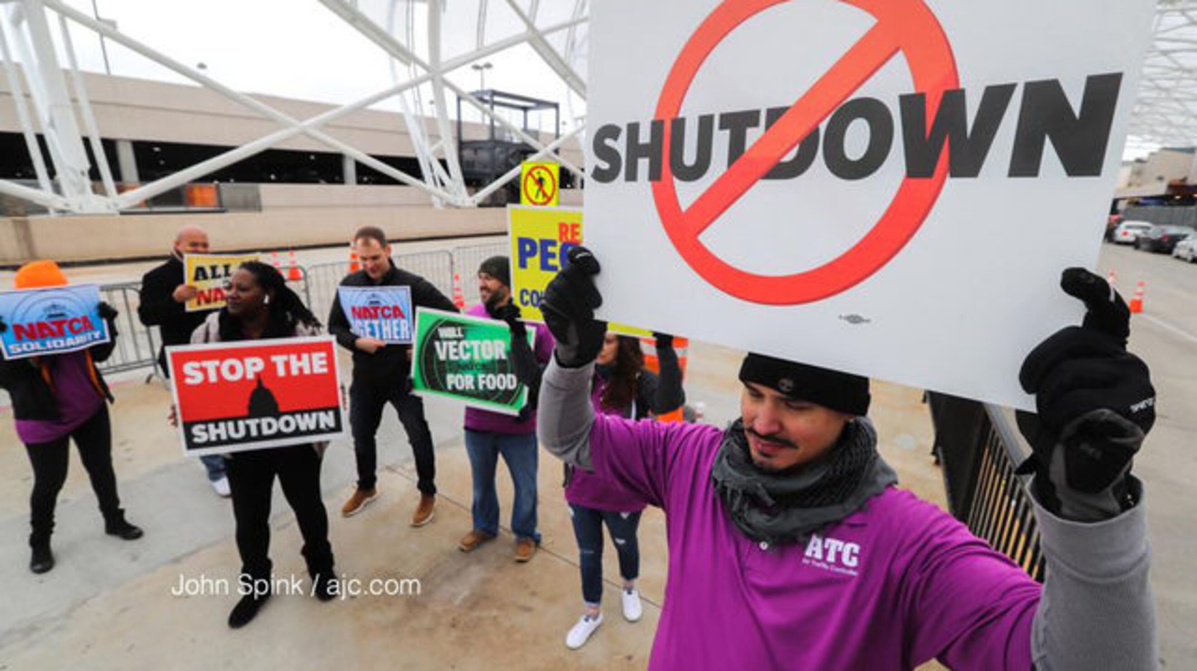 <p>Air traffic controller Rafael Naveira and fellow ATC workers protest the federal shutdown at the north terminal. Photo: JOHN SPINK / AJC<br /> </p>