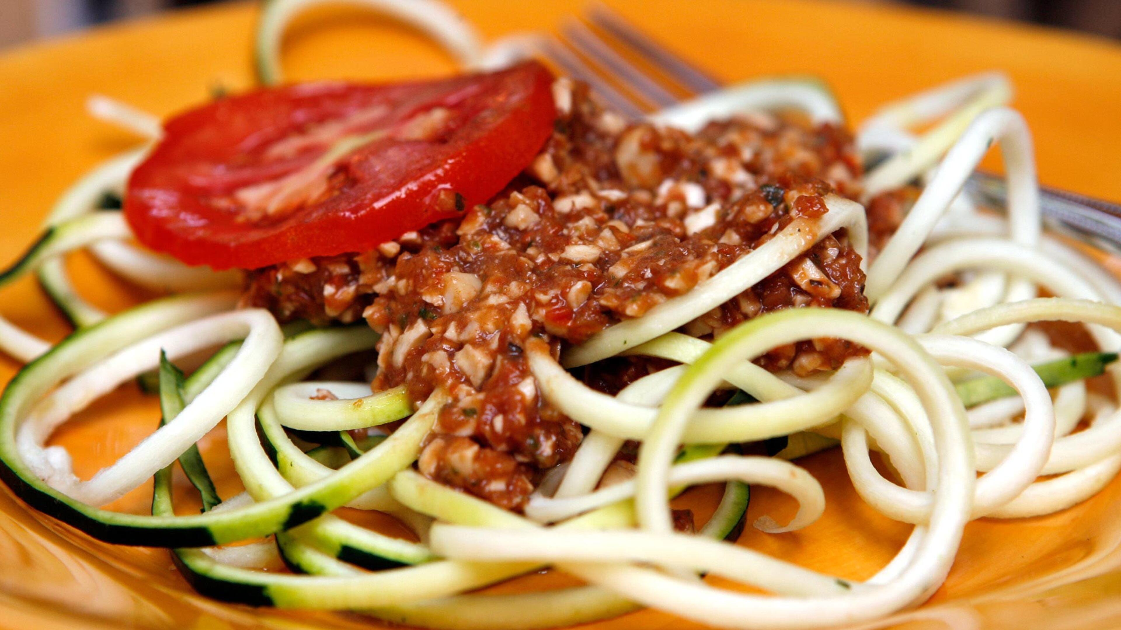 Spicy spaghetti sauce atop zucchini pasta. The sauce is made of sundried tomatoes, cashews, fresh tomatoes and select other raw, uncooked ingredients.