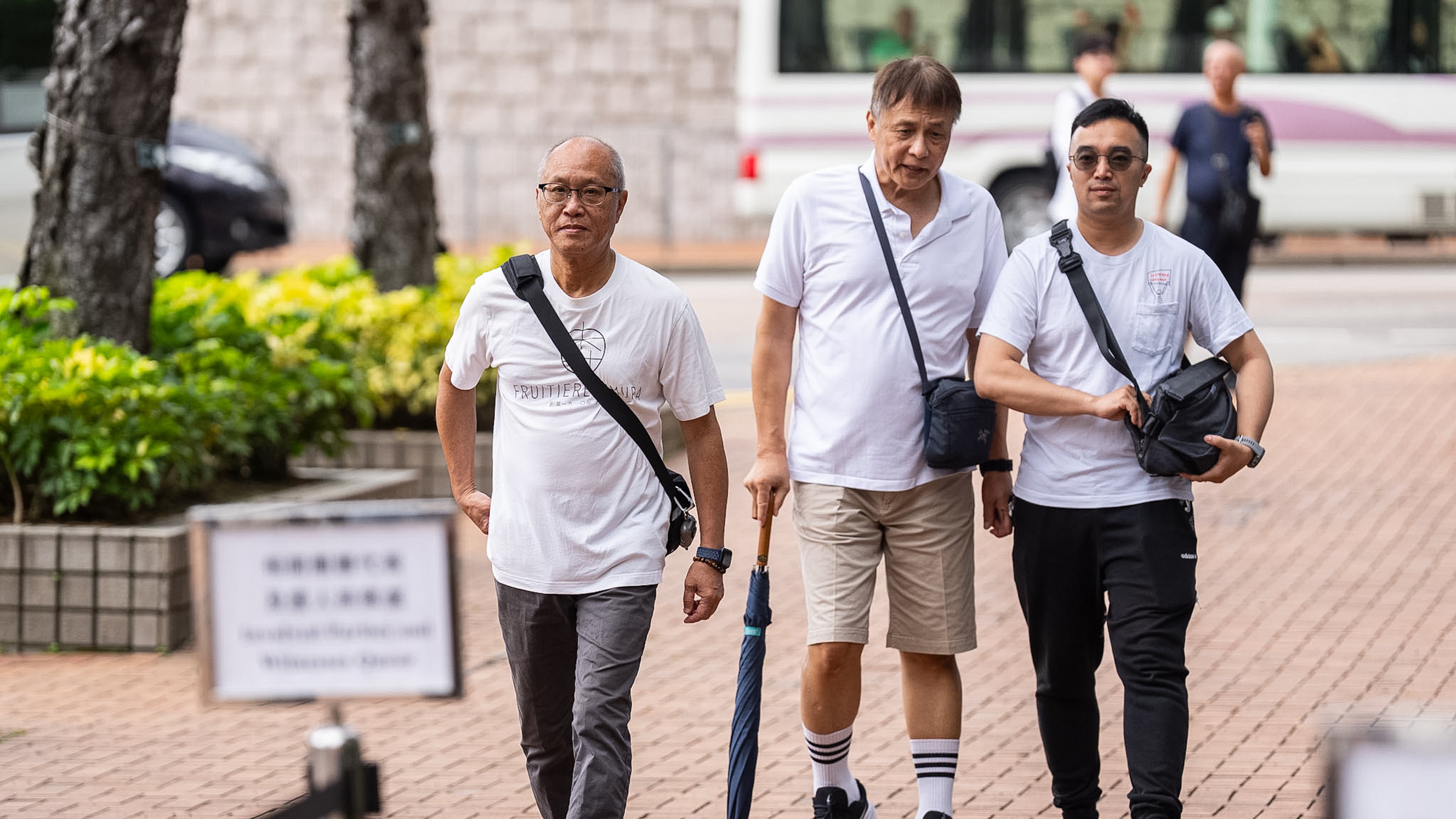Yip Ka Kui, left, a family member of a victim of the last year's deadly fire, arrives for the independent committee hearing in Hong Kong, Wednesday, July 15, 2026. (AP Photo/Chan Long Hei)