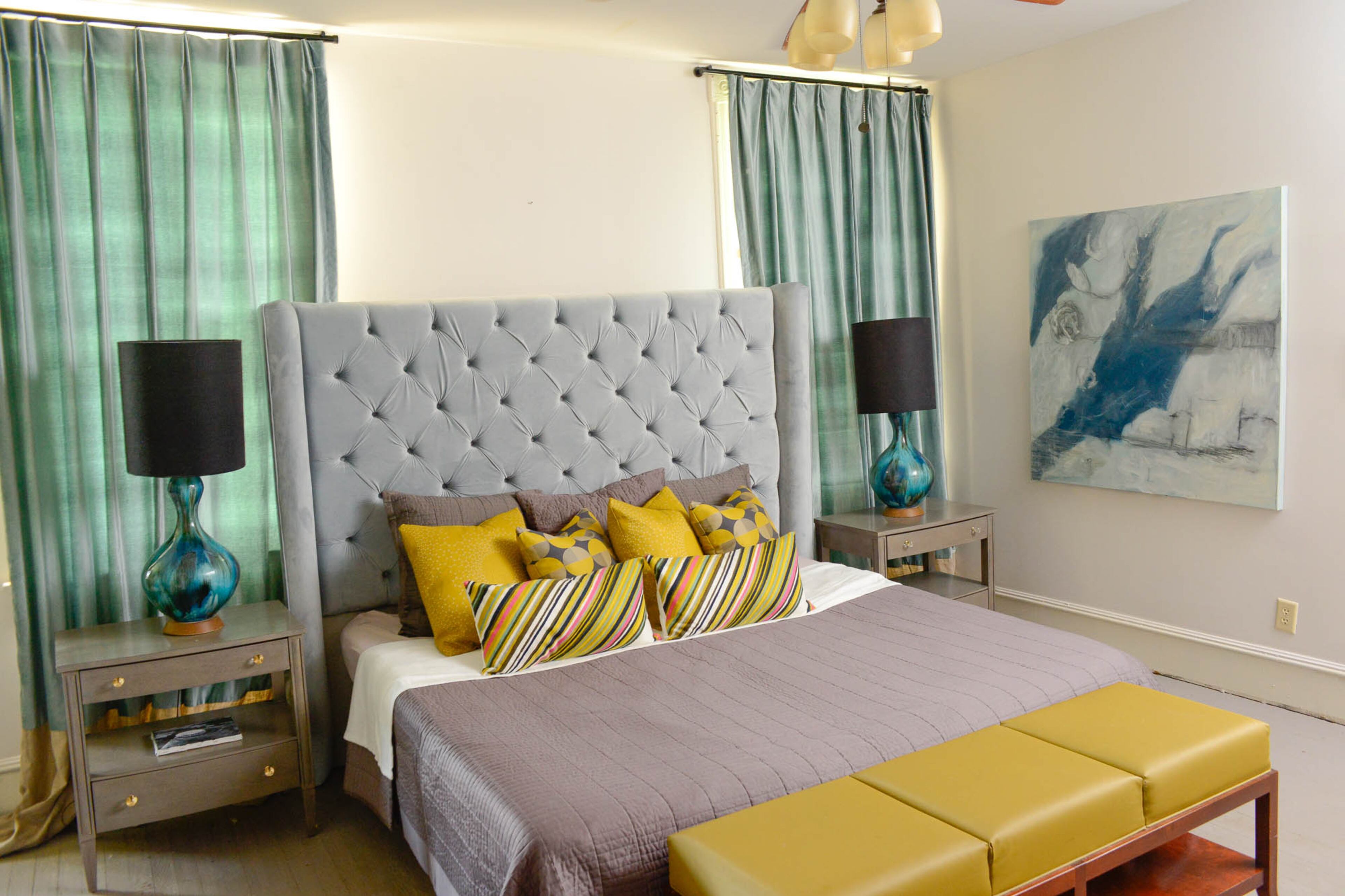 Custom furniture includes the velvet tufted headboard made by Ishmael’s business. The cooler colors and soft textures in the master bedroom create a relaxing retreat in the 121-year-old home.