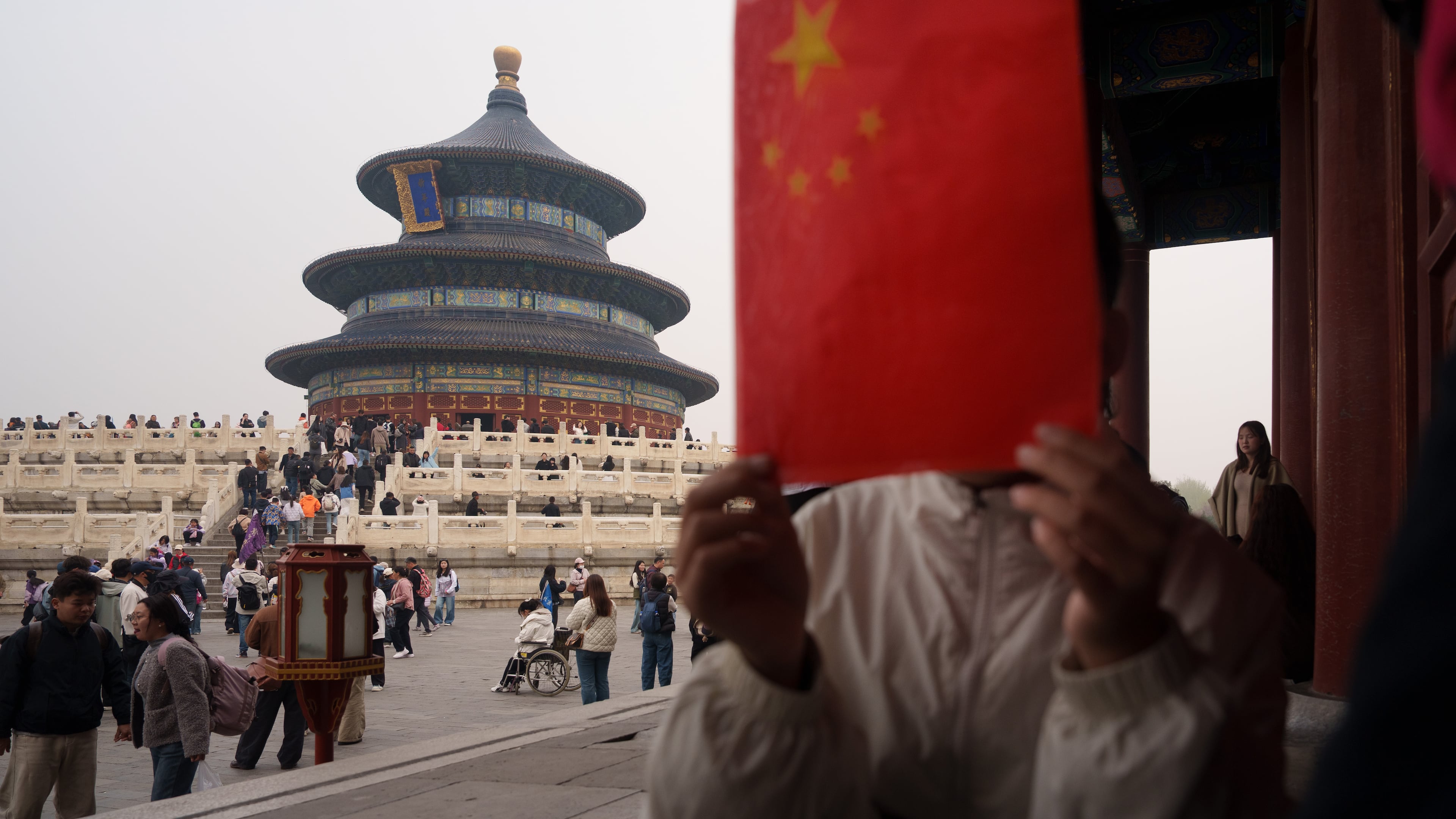 A children hold a Chinese national flag near the Hall of Prayer for Good Harvests at the Temple of Heaven in Beijing, China, Friday, April 3, 2026. (AP Photo/Vincent Thian)