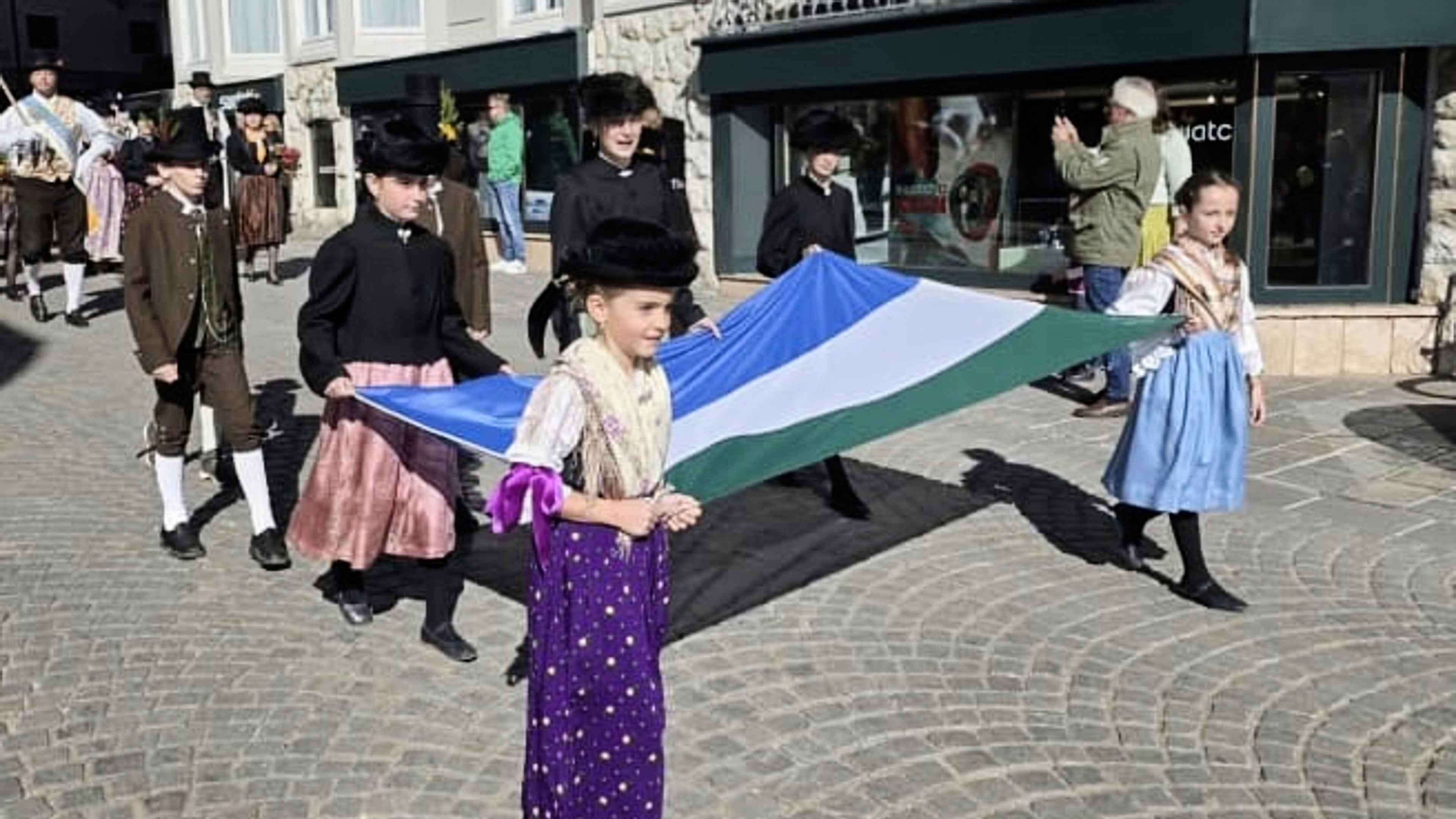In this undated handout photo, people carry a traditional Ladin flag during a parade through the streets of Cortina D'Ampezzo, northern Italy, Monday, Jan. 26, 2026. (ULdA, Ampezzo Ladin Union via AP)