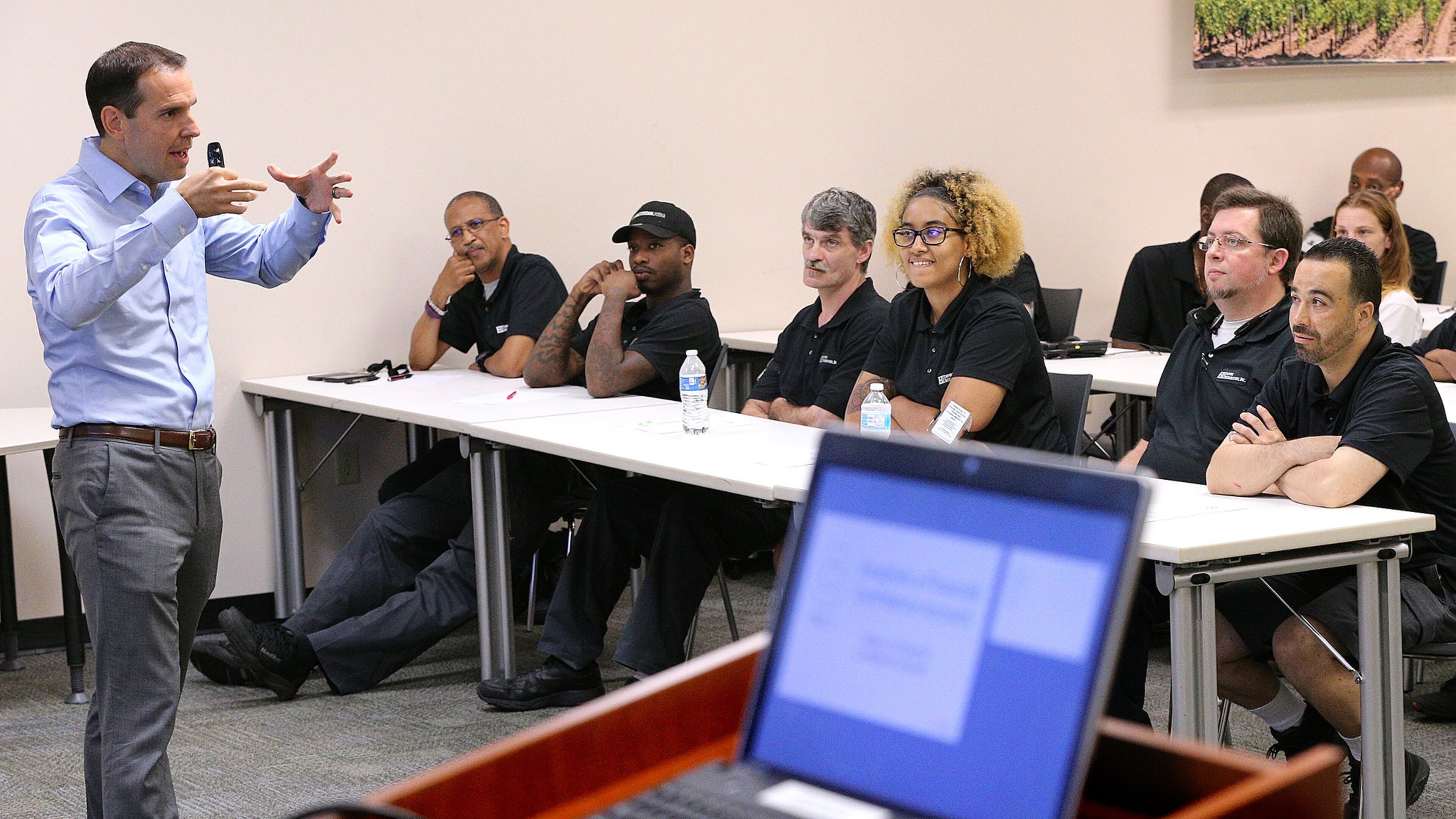 Brian Nelson Ford (from left) presents a personal financial wellness event while Empire Distributors employees Gerald Johnson, Frank Booker, Jimmy Mullally, Chantel Walker, Jeff Hawkins, and Jeff Aragones Esparra look on. Some employers are rolling out more robust programs to convince workers to improve their own personal finances. Curtis Compton/ccompton@ajc.com
