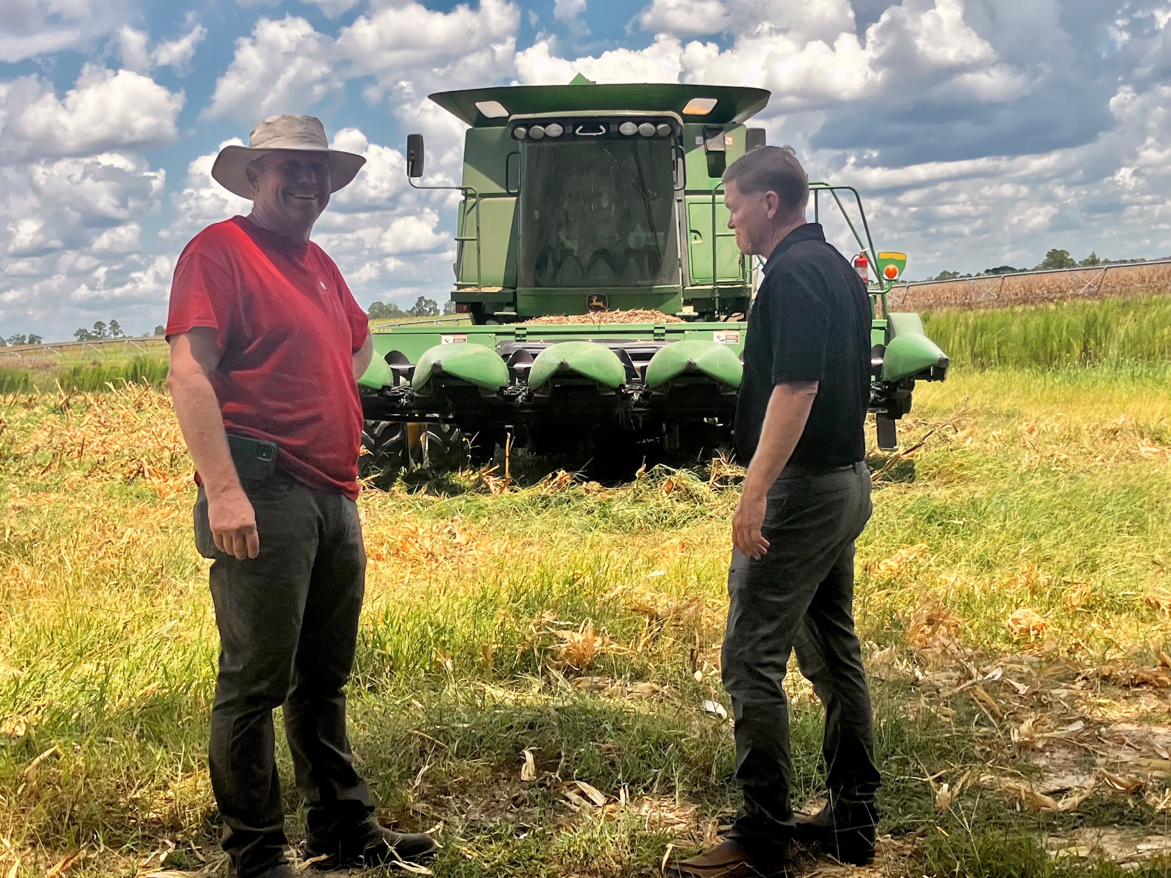 Georgia farmer Jason Braddy (left) and Jim Gillis, a supervisor for the state Department of Natural Resources, share a shady spot on the edge of one of Braddy's fields. Tegus, said Braddy, may be like armadillos — an invasive species that just won't go away. Braddy shot one from his truck. (Mark Davis for the AJC)