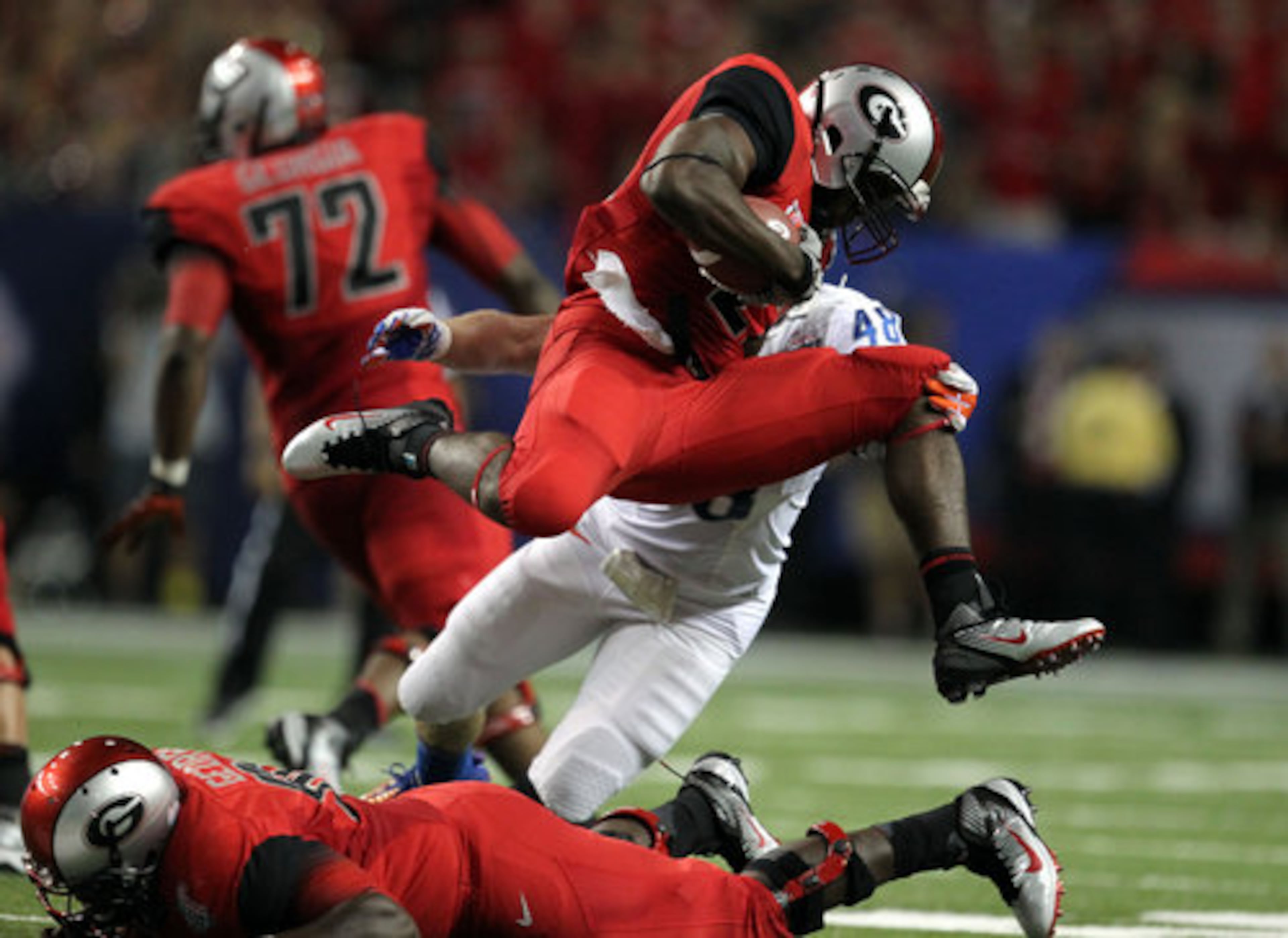 Georgia running back Richard Samuel jumps over a lineman as Boise State linebacker J.C. Percy makes the tackle.