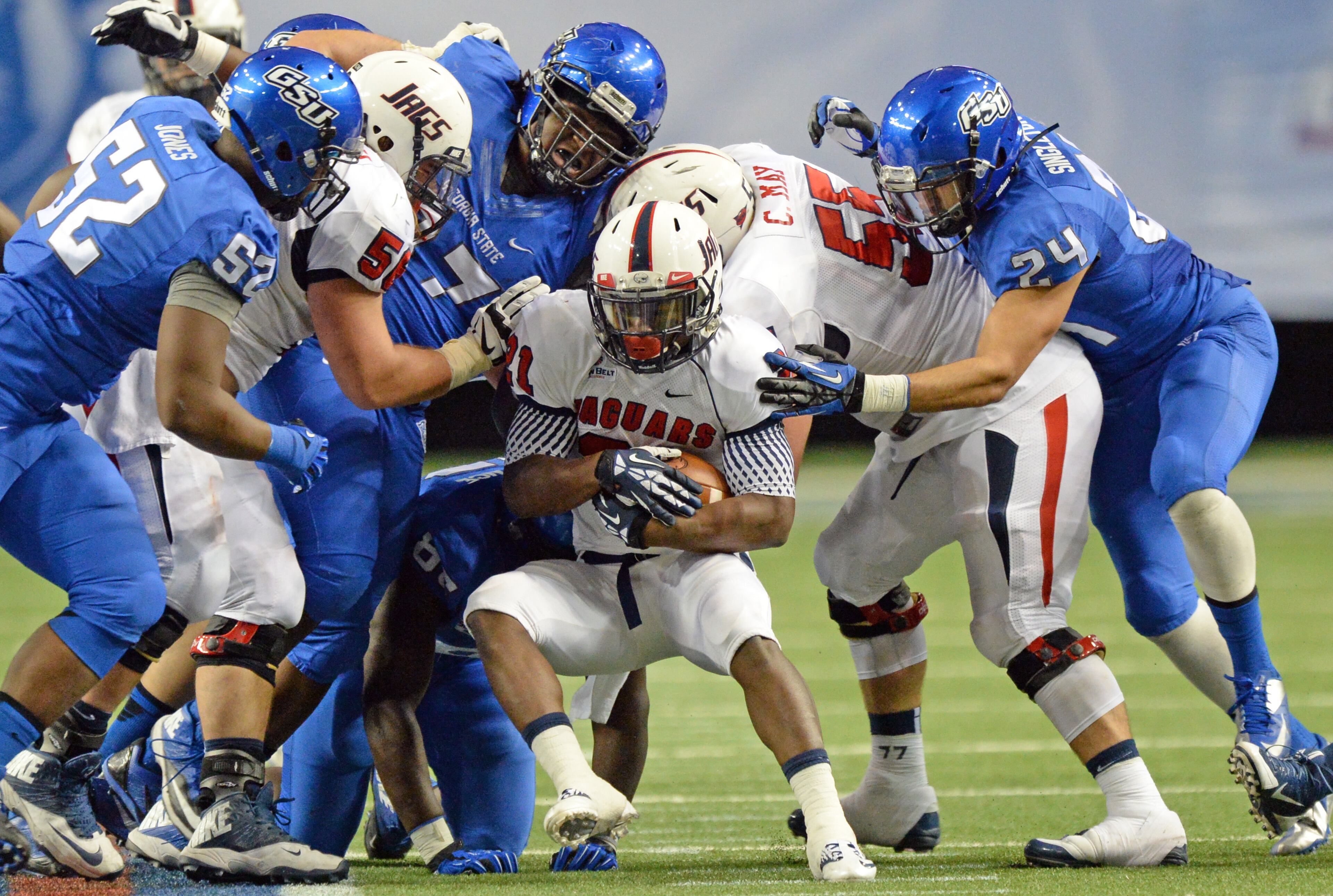 South Alabama Jaguars running back Terrance Timmons (center) pushes for an extra yard with Georgia State Panthers defenders in the second half on Saturday, November 30, 2013, at the Georgia Dome. South Alabama Jaguars won 38 - 17.