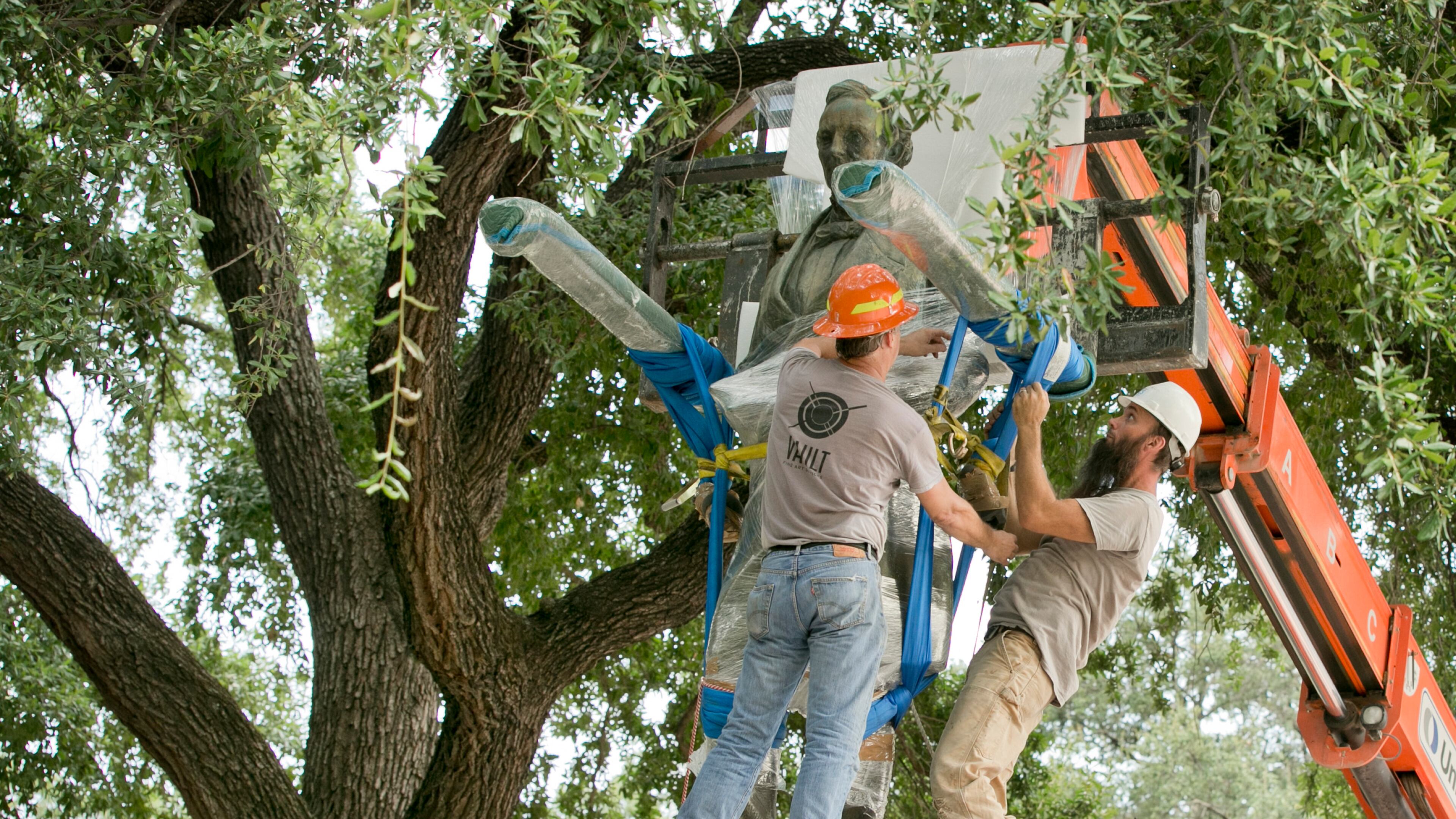 Crews remove the Jefferson Davis statue from the Main Mall on the UT campus on Sunday.