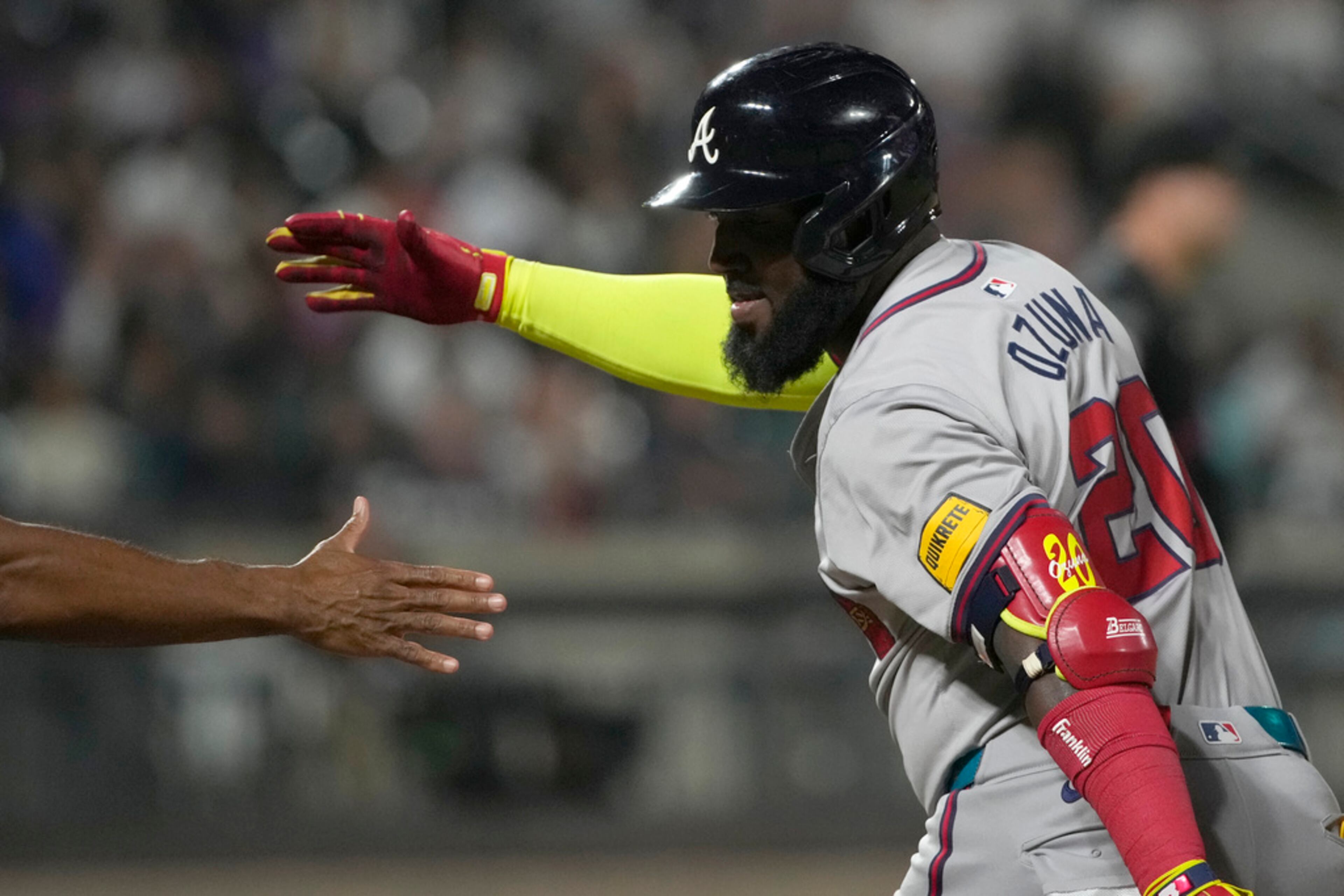 Atlanta Braves' Marcell Ozuna, right, celebrates with first base coach Tom Goodwin after hitting a single during the eighth inning of a baseball game against the New York Mets, Friday, July 26, 2024, in New York. (AP Photo/Pamela Smith)