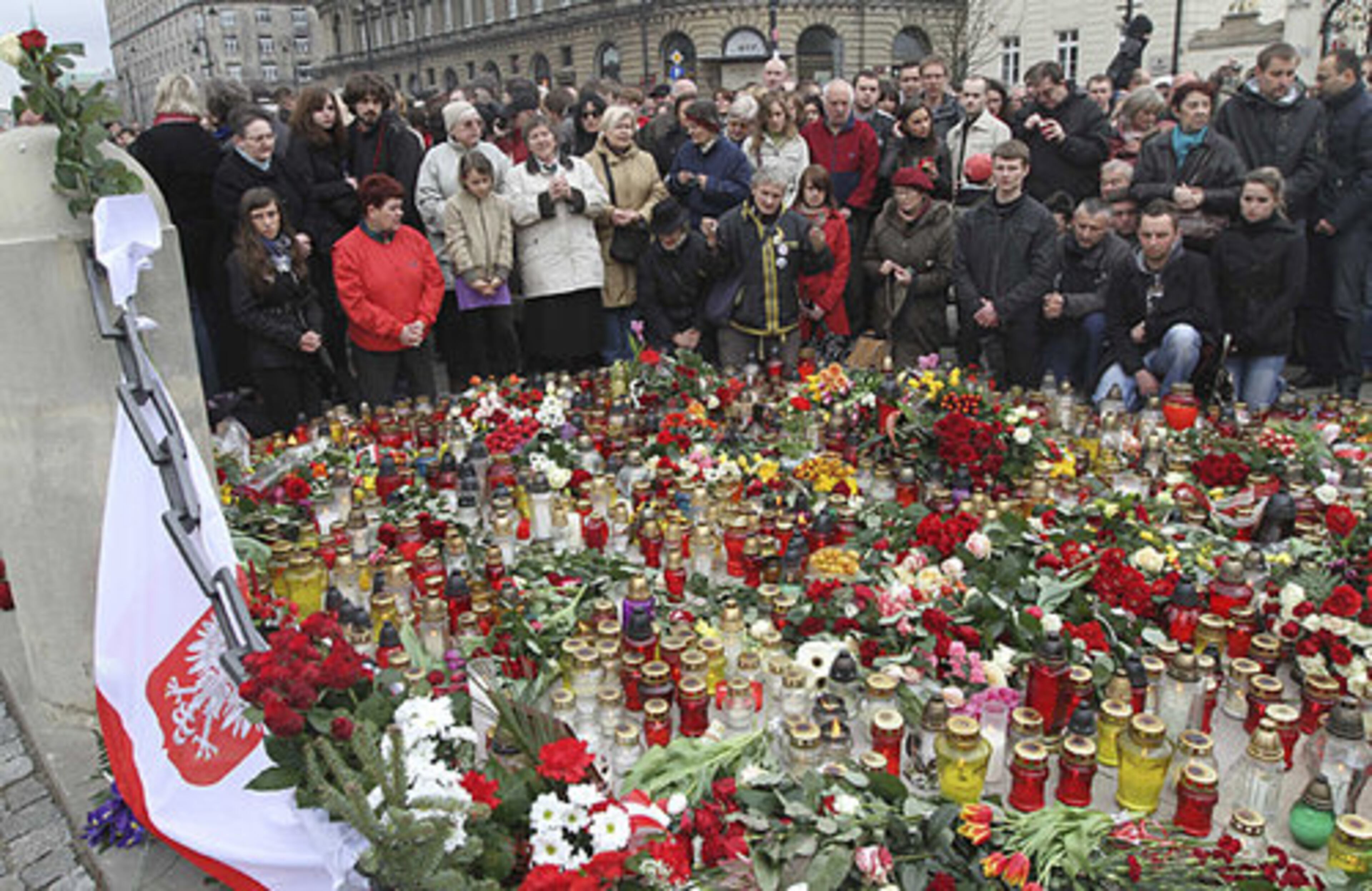 People light candles and lay flowers in front of the Presidential Palace in Warsaw.
