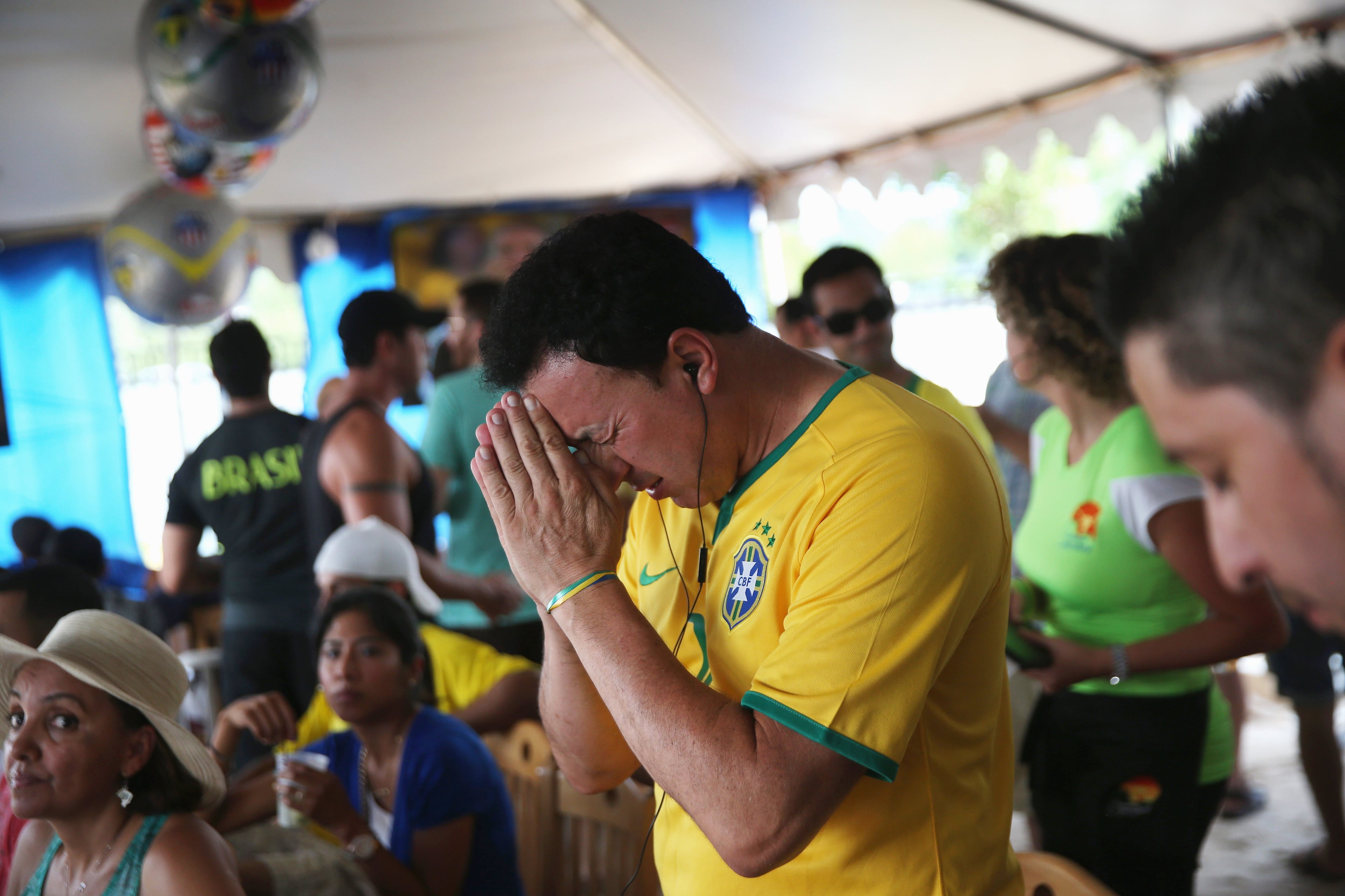 A Brazilian fan prays before the semifinal World Cup game against Germany on July 8, 2014 in Port Chester, United States. Fans, mostly for Brazil, gathered at the Copacabana Restaurant in Westchester County to watch on outdoor TV screens. (Photo by John Moore/Getty Images)
