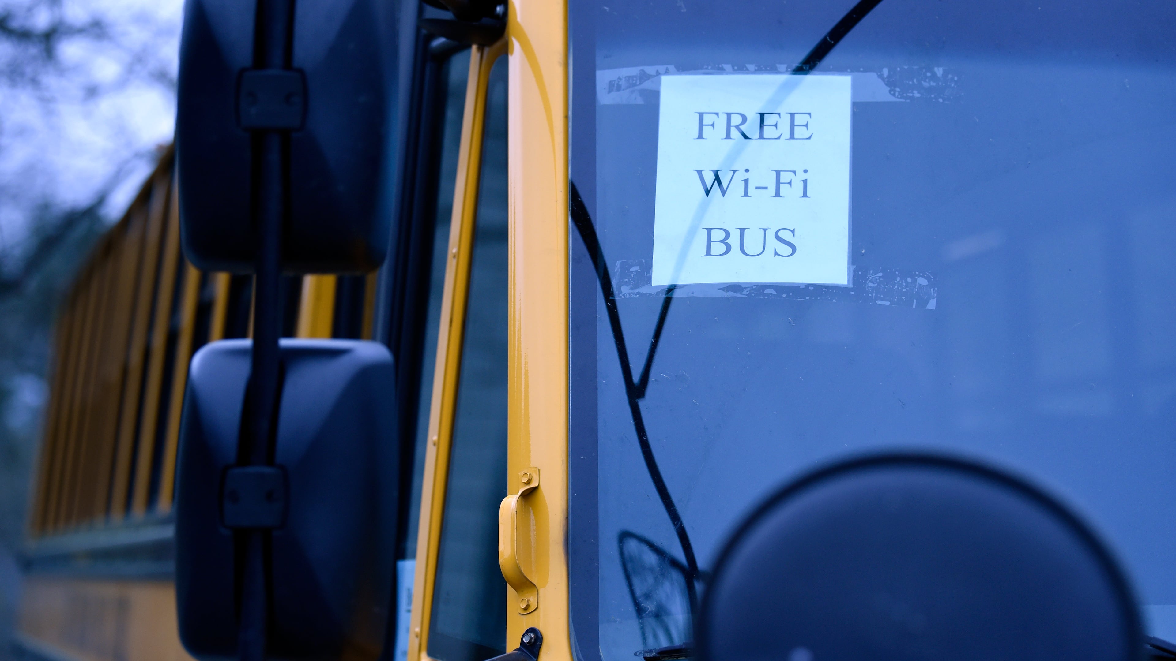 In this Thursday, March 26, 2020, photo, this wi-fi-enabled school bus, seen at an apartment complex in Winnsboro, S.C., is one of many being sent to rural and lower-income areas around South Carolina to help students with distance learning during the new coronavirus outbreak. With routers mounted inside, the buses broadcast enough bandwidth in an area the size of a small parking for parents to drive up and children to access the internet from inside their cars. (AP Photo/Meg Kinnard)