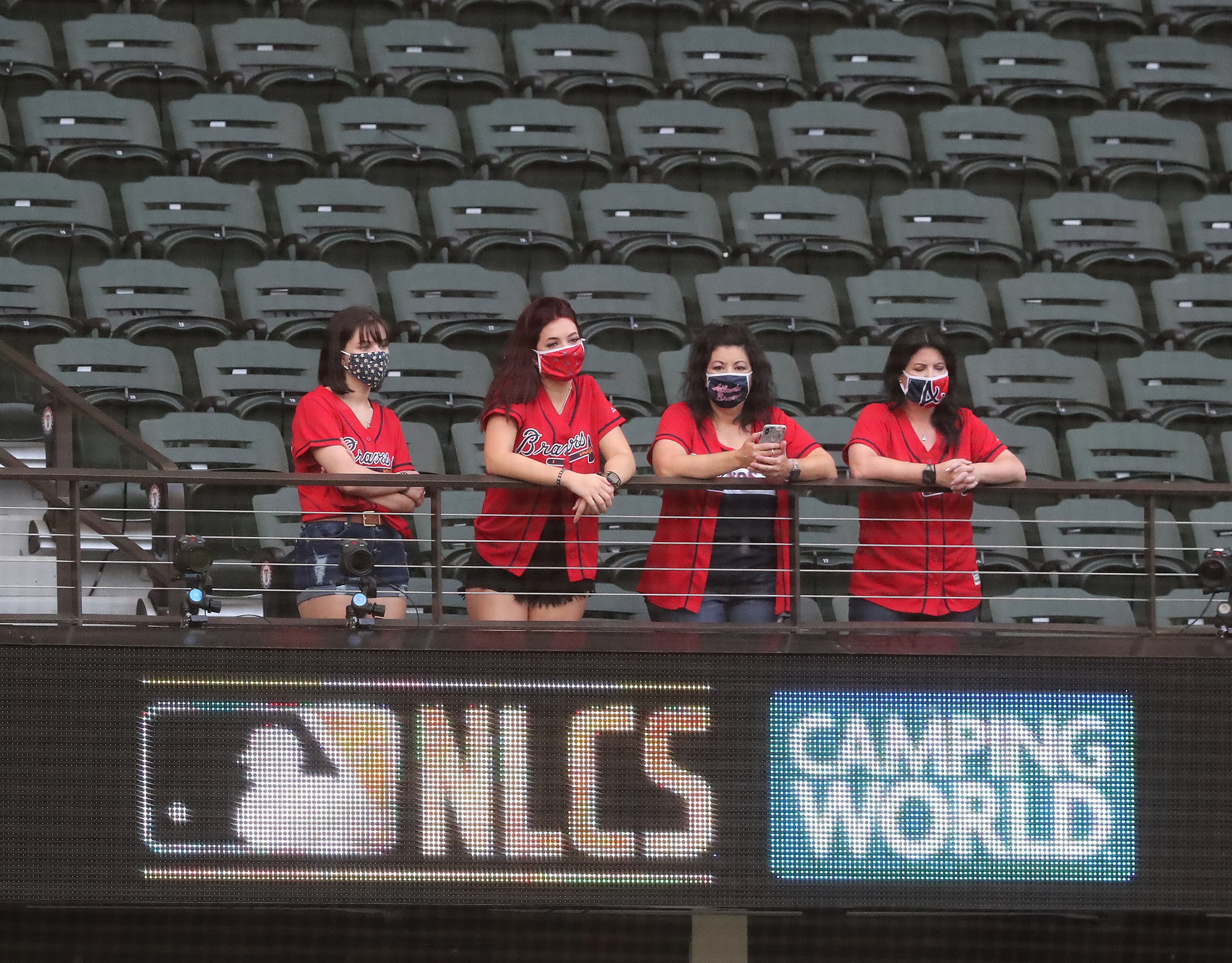 With seating limited to a maximum group of four at Globe Life Field some Braves fans sport their team shirts while watching the Braves prepare to play the Dodgers in Game 7 of the National League Championship Series Sunday, Oct. 18, 2020, in Arlington, Texas. (Curtis Compton / Curtis.Compton@ajc.com)