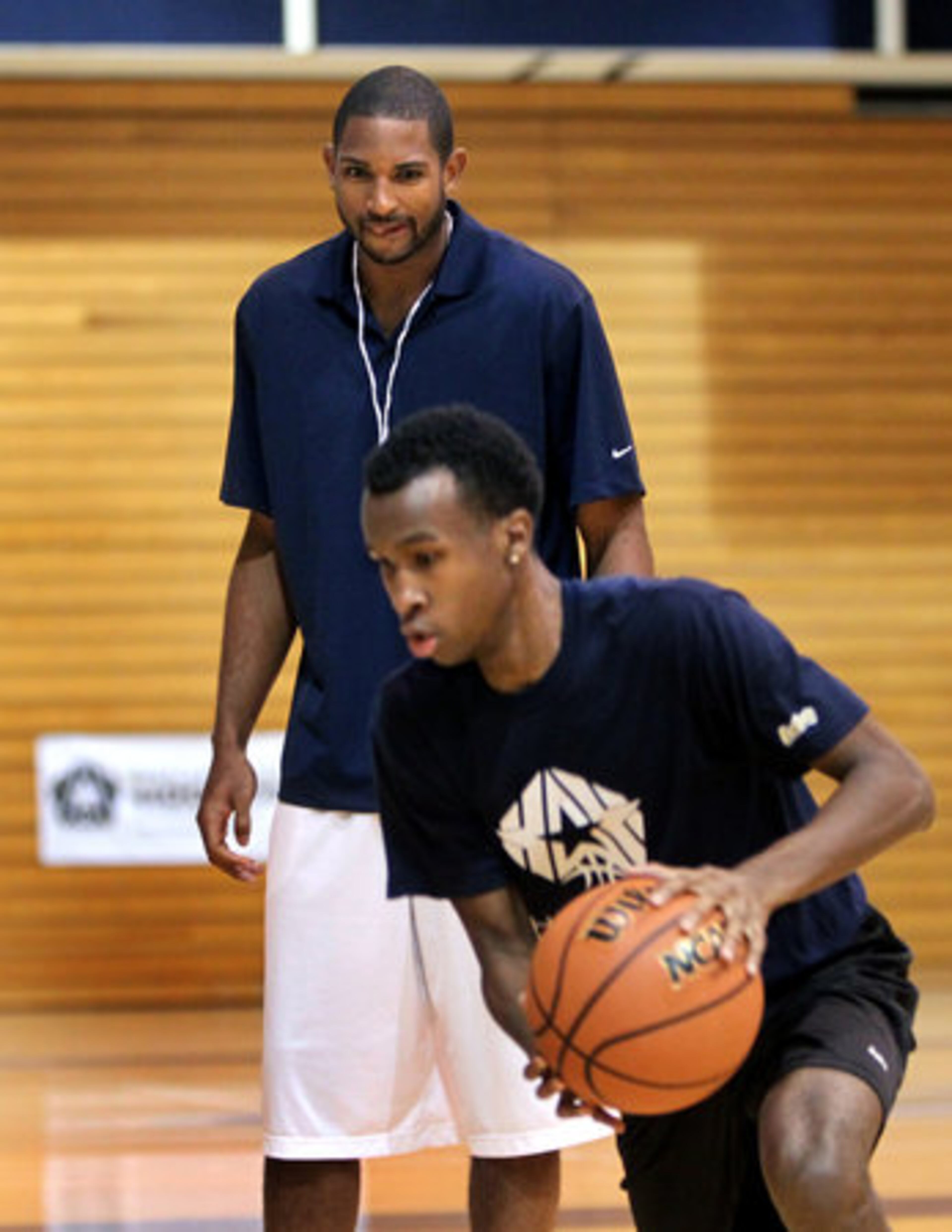 Atlanta Hawks forward Al Horford, top, watches as Edward Ravenel, 18, participate in a drill during Horford Hoopstars Basketball Camp.