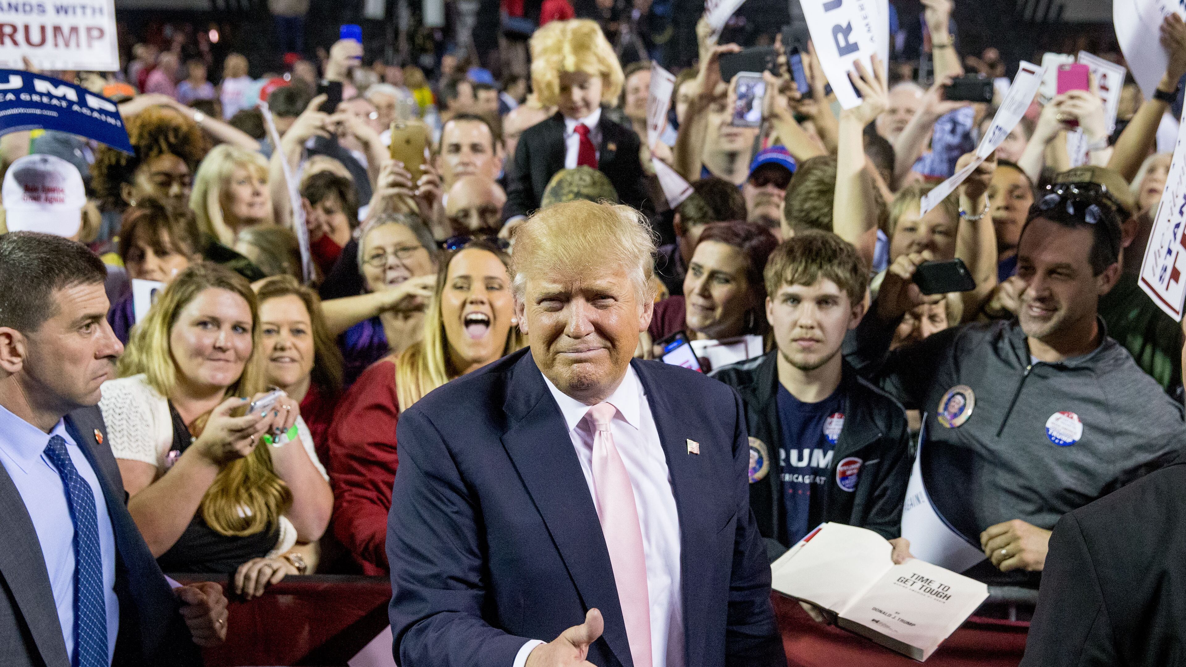 Republican presidential candidate Donald Trump poses for photographers with Colton Jordan, 5, of Cario, Ga., top, who dresses up like Trump following a rally at Valdosta State University in Valdosta, Ga., Monday, Feb. 29, 2016. (AP Photo/Andrew Harnik)