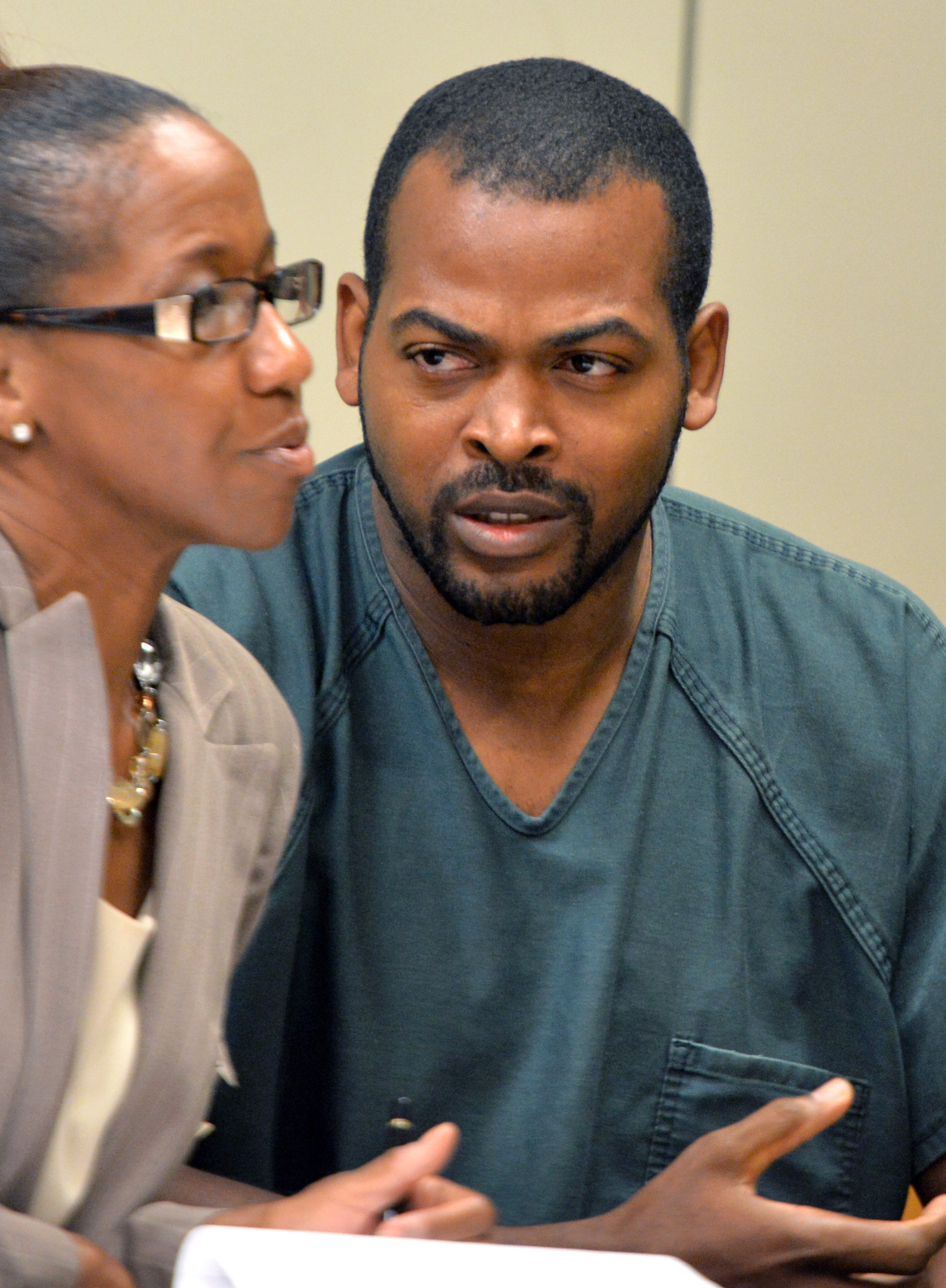 July 10, 2014 Lawrenceville - Recardo Wimbushat (right) speaks to his defense attorney Teri Thompson looks during a hearing before Gwinnett chief magistrate Christina Blum at Gwinnett Magistrate Court in Lawrenceville on Thursday, July 10, 2014. Bond has been denied for Recardo and Therian Wimbush being held on child cruelty charges that they kept their oldest child a prisoner in their home. HYOSUB SHIN / HSHIN@AJC.COM