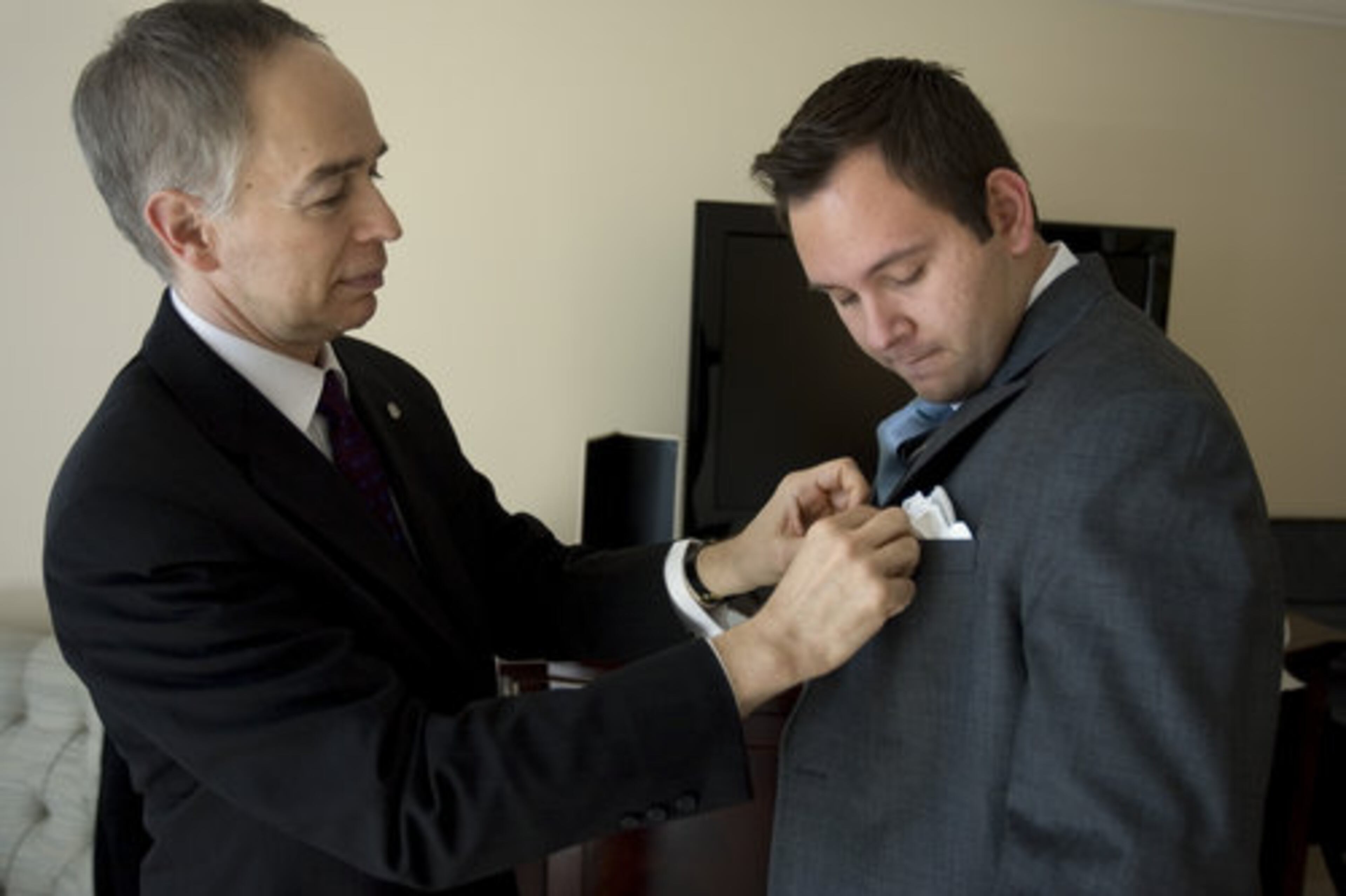 Philip DeAngelis (left) helps Thomas Gauthier with his new butler uniform at the St Regis hotel in Atlanta. DeAngelis is the head butler with the St. Regis hotel in New York City and Gauthier is training for his butler position in Atlanta's new St. Regis set to open next week.